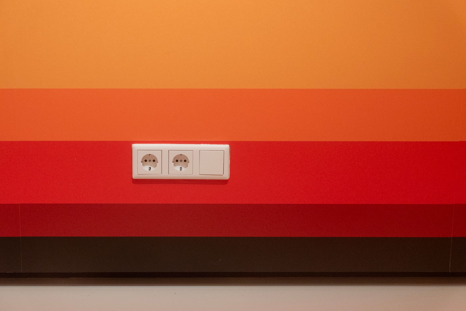 A commercial wall receptacle provides power beside the equipment area without a cable crossing the walkway.