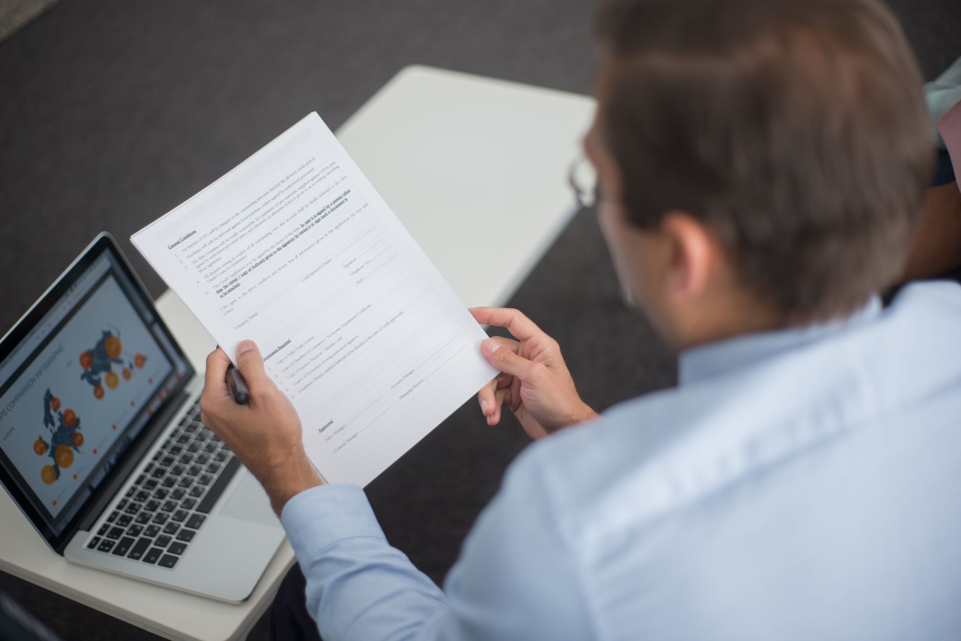 A manager reviewing a software contract on a laptop, the kind of renewal review where robot license caps get negotiated.