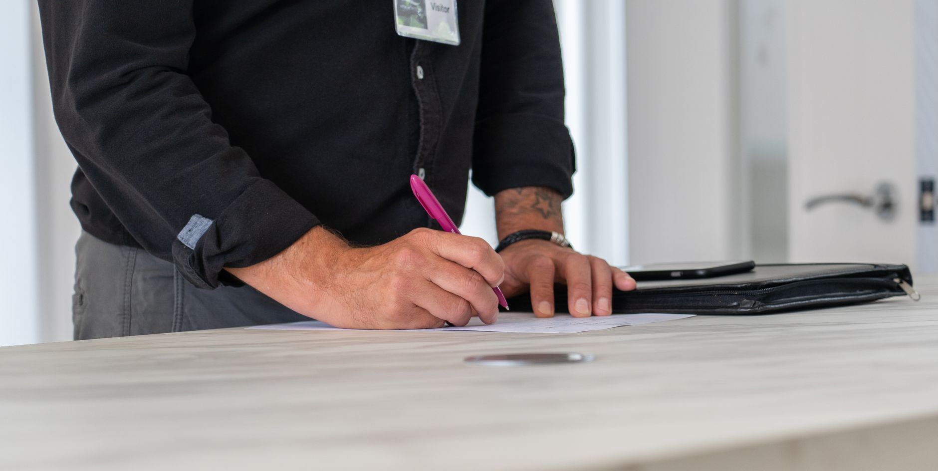 A visitor stopping at a security check-in point, matching the article’s human-reviewed visitor screening workflow.