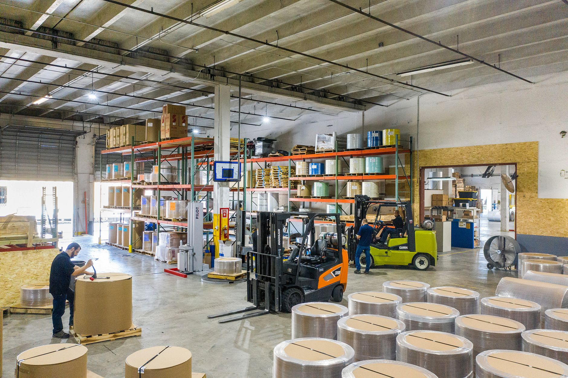 Palletized paper or printed work staged at a repeatable handoff point inside a print plant.