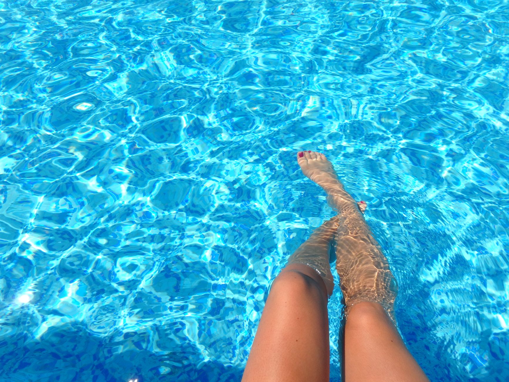 A wet outdoor resort walkway near a pool area, illustrating how weather and slick surfaces can complicate resort delivery routes.