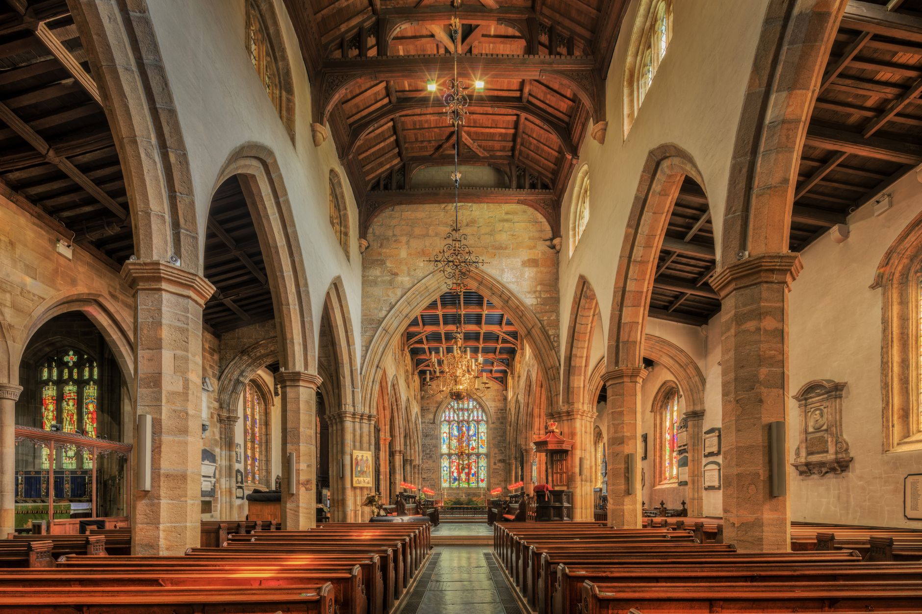 A carpeted church sanctuary with rows of seating and center aisles, reinforcing the article’s guidance about vacuuming, moisture control, and fast spill response.