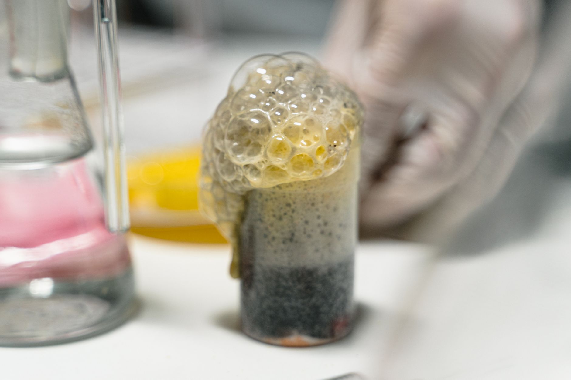 Foaming liquid in laboratory glassware during a controlled compatibility screen.
