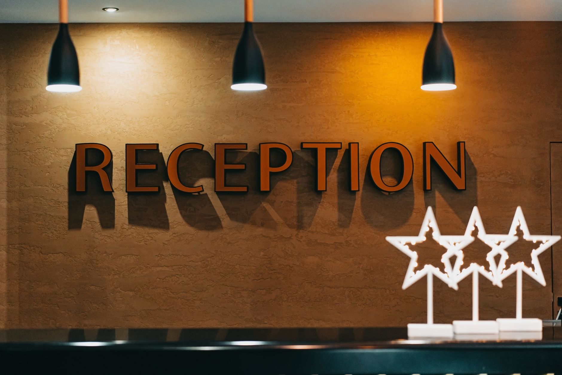A wide, modern hotel lobby with complex furniture arrangements, representing a dynamic environment where a remote operator's help might be needed.