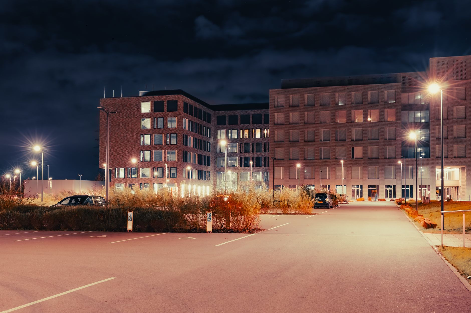 An outdoor view of a modern corporate campus at dusk, an example of a large area that could be monitored by autonomous security patrol robots.