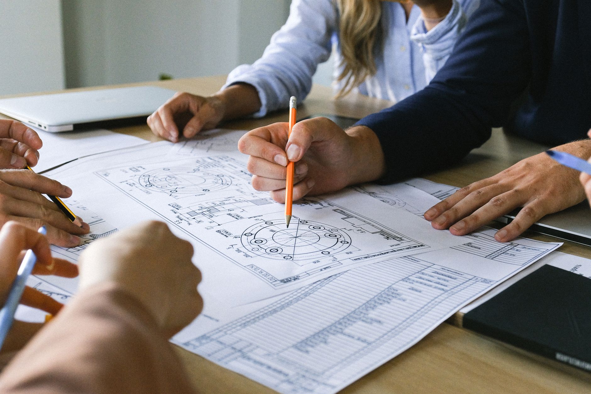 Two professionals analyze financial charts and plans in a modern office, representing the core decision of building an in-house robotics team or partnering with an integrator.