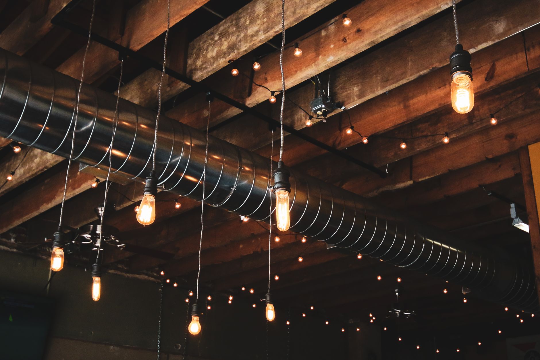 High warehouse rafters and overhead services illustrate the open air volume where a guarded indoor drone can scout quickly.