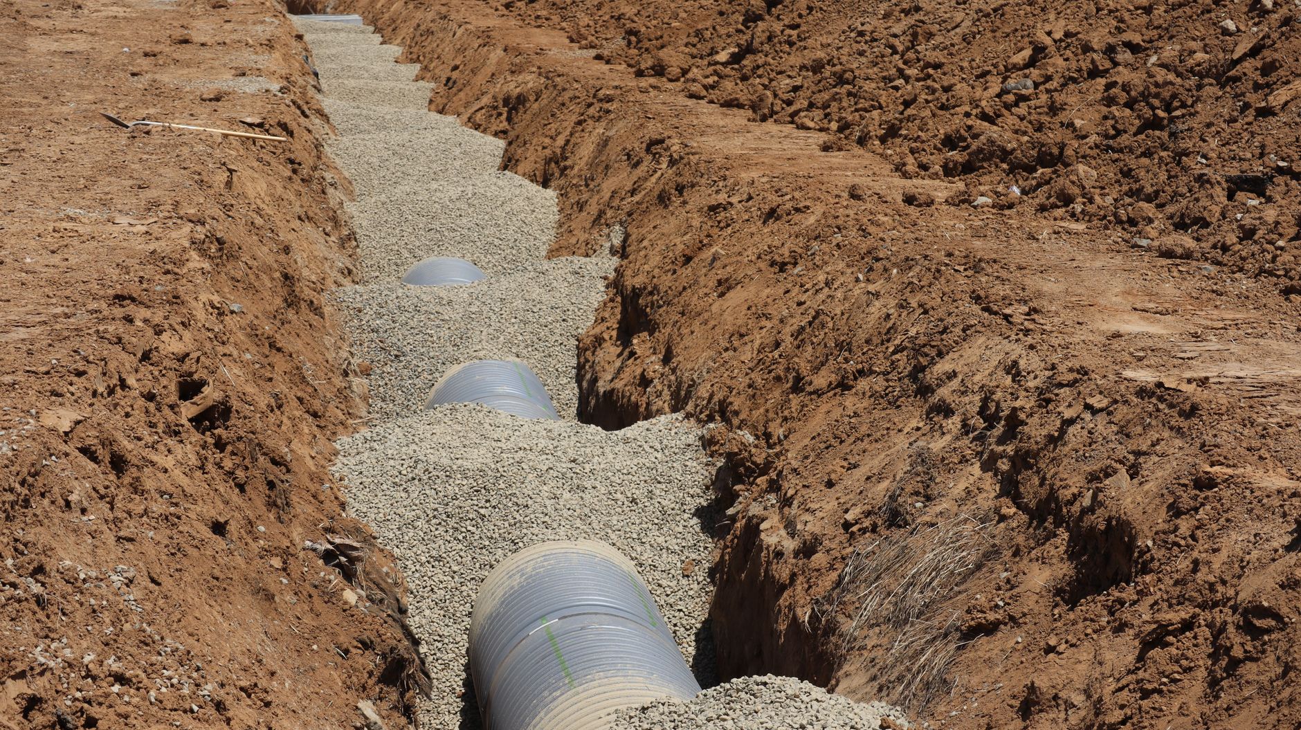 Drainage trench at an industrial site where confined space gases can accumulate after storms.