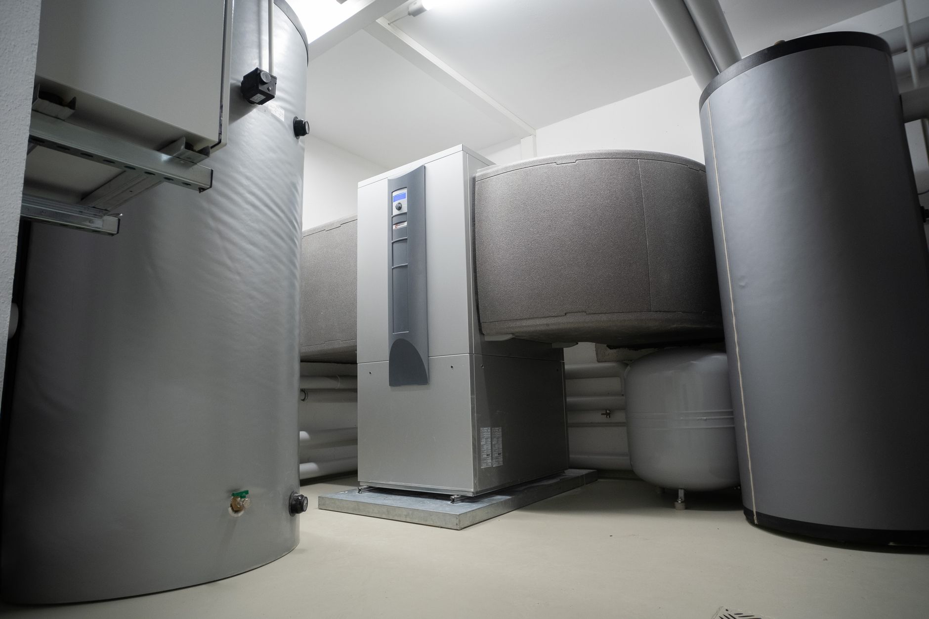 Pumps, pipes, valves, and filtration equipment inside a humid commercial pool mechanical room.