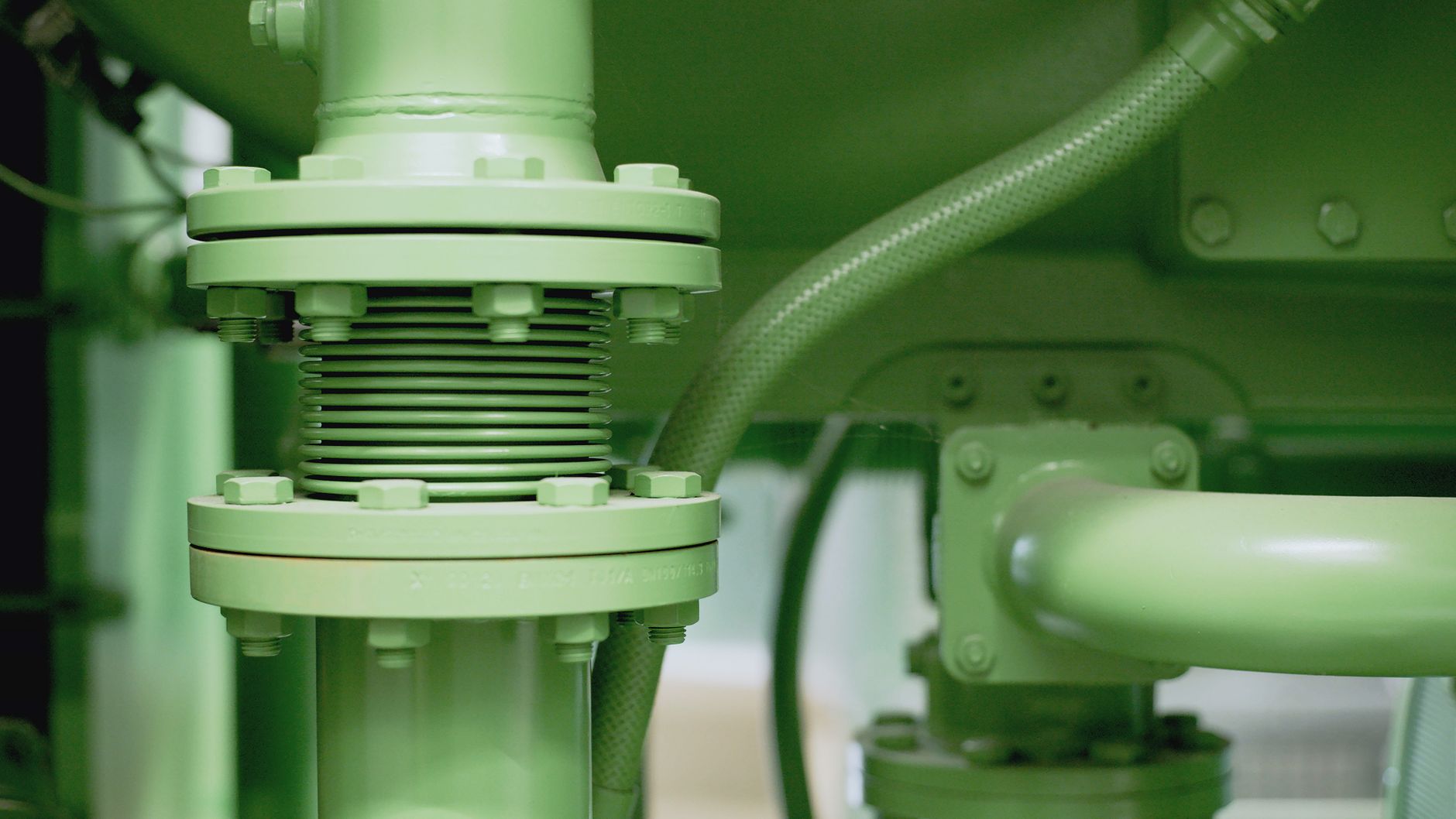A close view of industrial pipe fittings where oil staining can reveal a developing refrigeration leak.