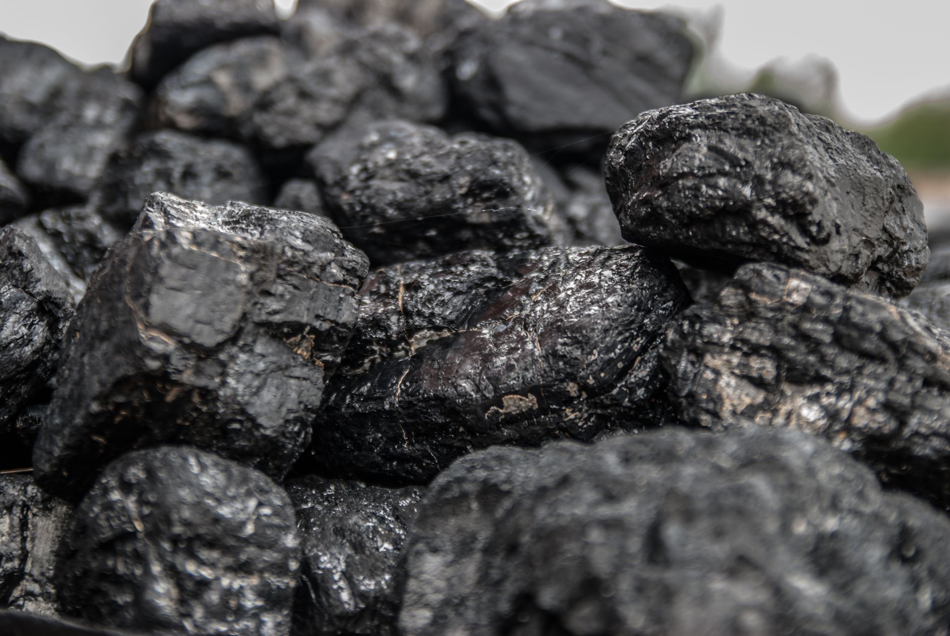 Piled bulk material at a processing plant, illustrating fines and buildup that collect in chute corners.
