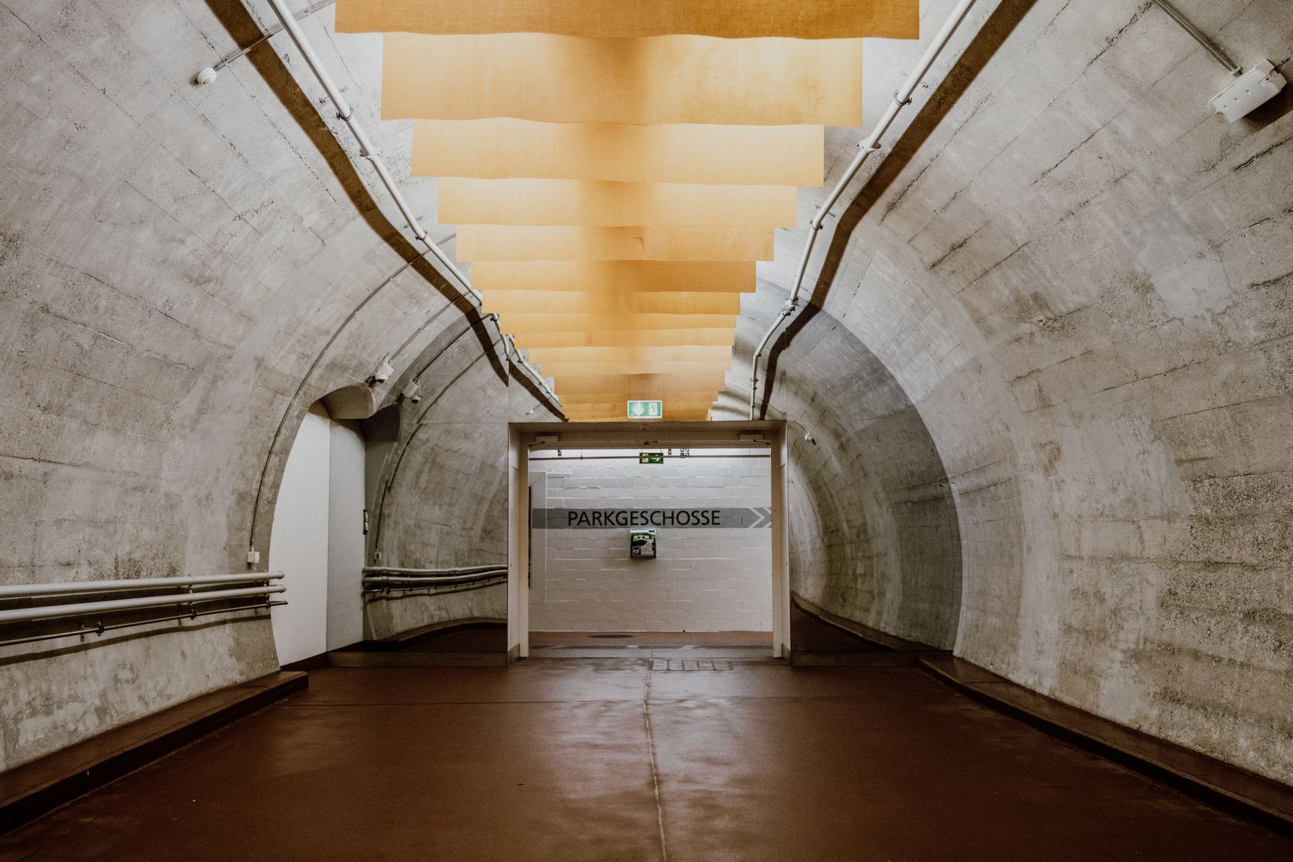 Hospital service corridor where utility tunnels branch toward steam, chilled water, and electrical feeds.