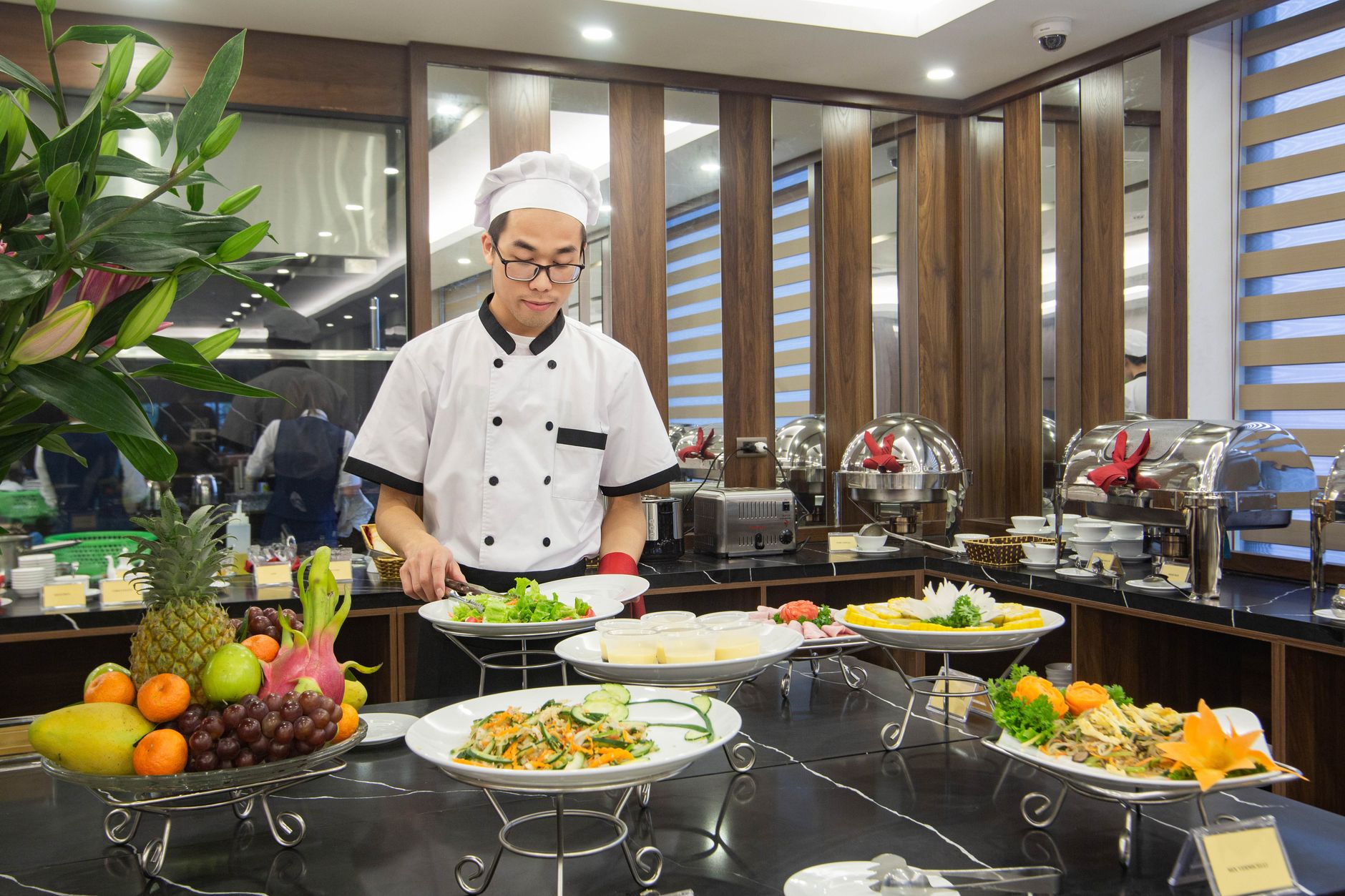 A large hotel kitchen with multiple prep and cooking stations, representing the complex exhaust systems found in hospitality properties.