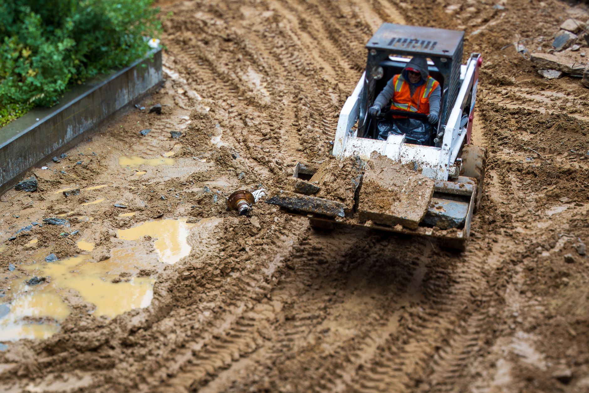 Soft, rutted mud on an outdoor work path, showing the footing challenges that break fixed routes on landfill caps after rain.