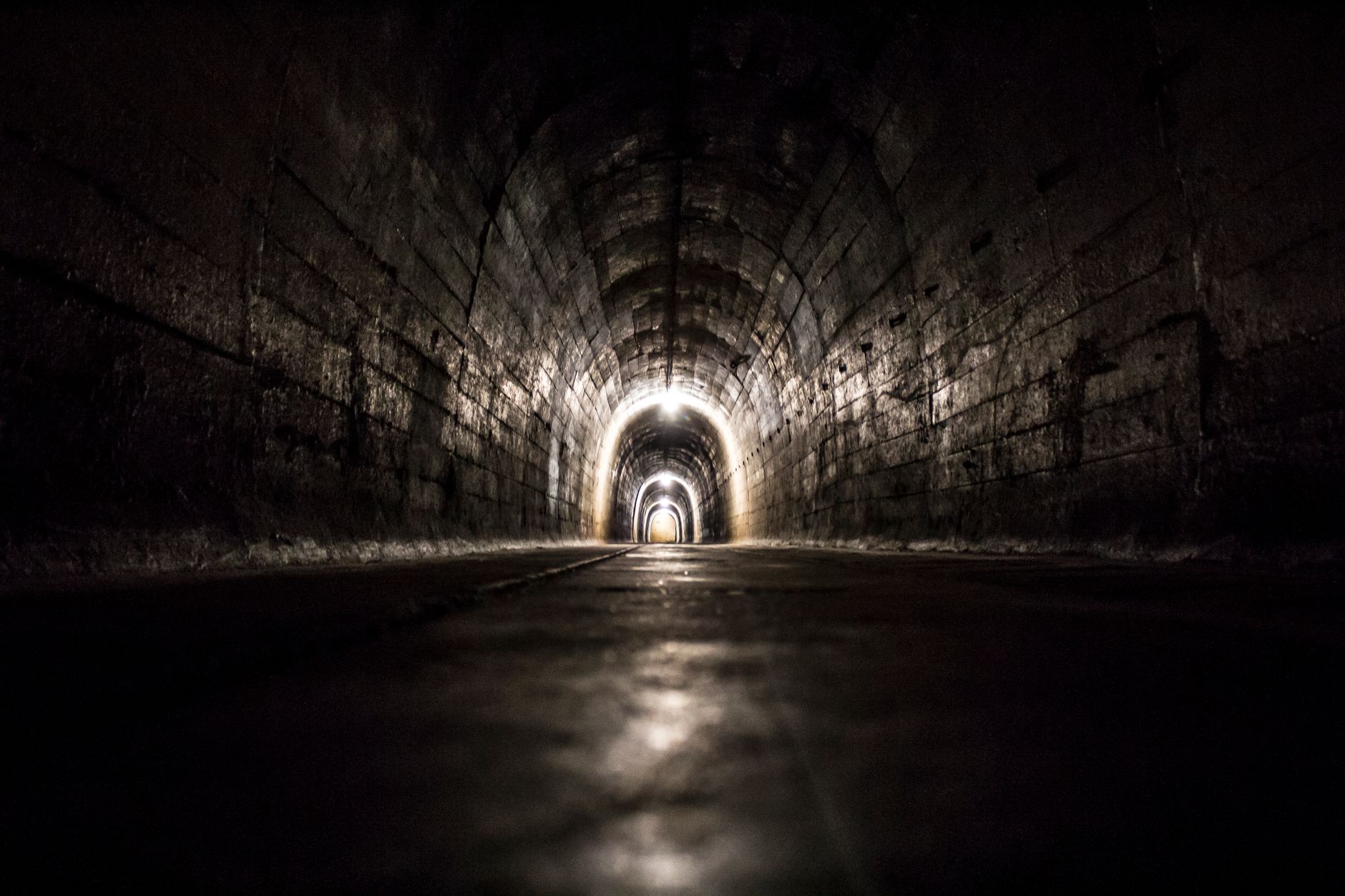 A tight, confined industrial space with wet surfaces and complex machinery, highlighting a dangerous work environment.