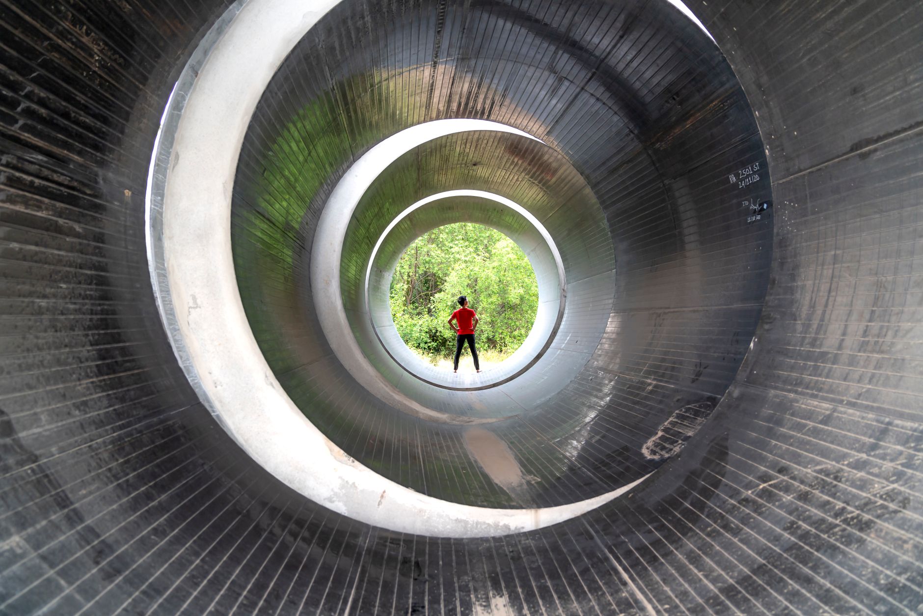 View from the inside of a large, dark concrete pipe, illustrating the environment crawler robots inspect.