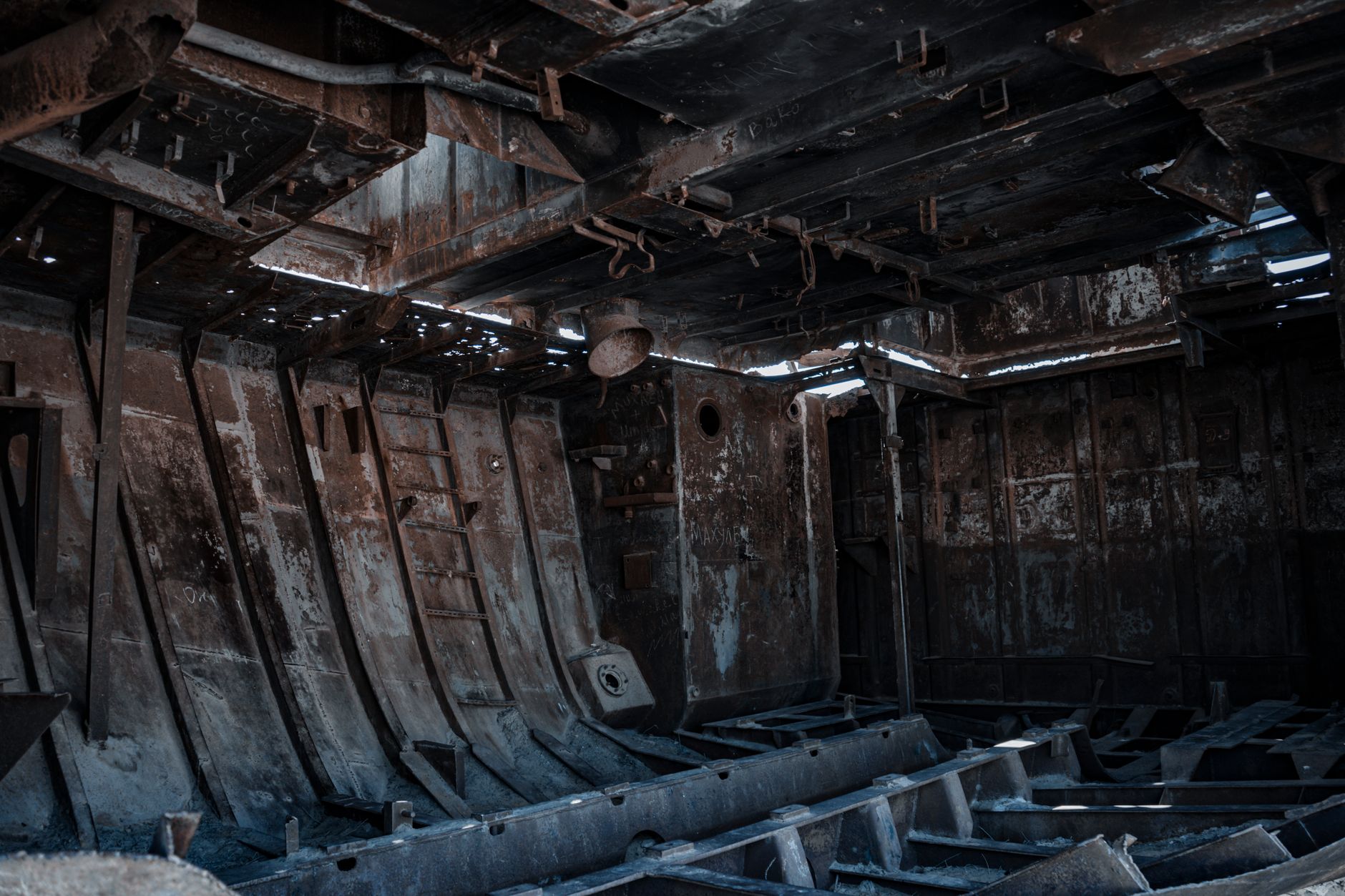 Dense steel framing inside a ship illustrates the enclosed bays and radio-shadow zones encountered during ballast tank surveys.