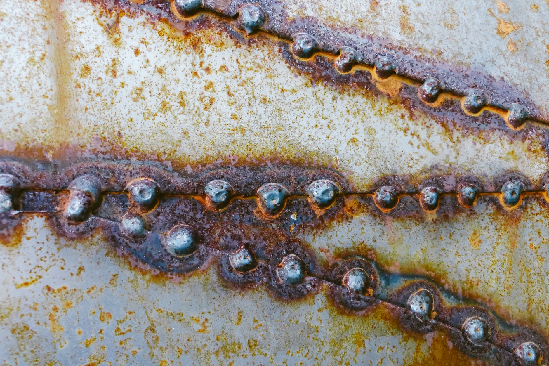 A close view of corroded steel shows rough scale, staining, and surface texture that can obscure inspection findings.