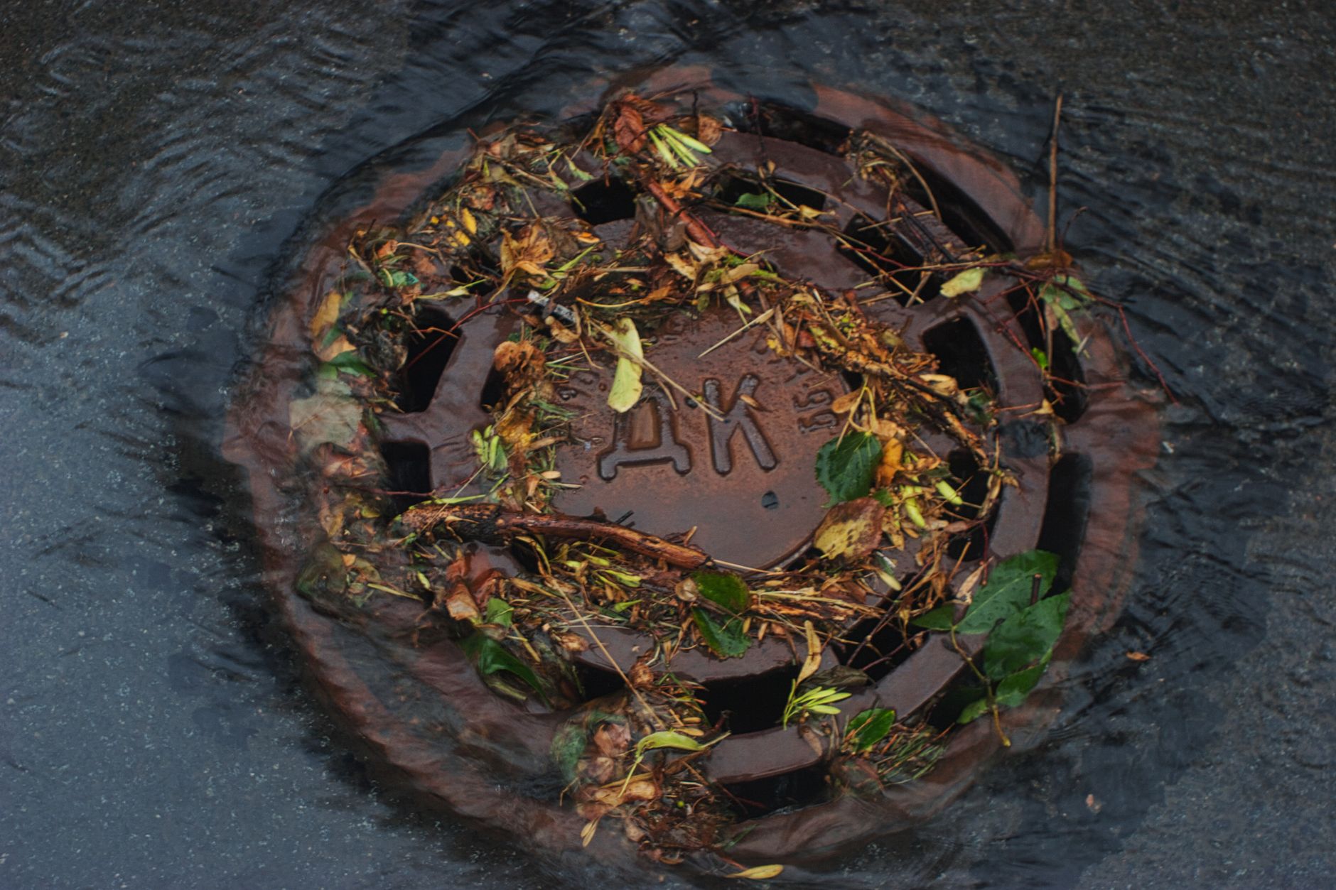 A street-level storm drain access point, the typical entry for inspecting an underground detention vault remotely.