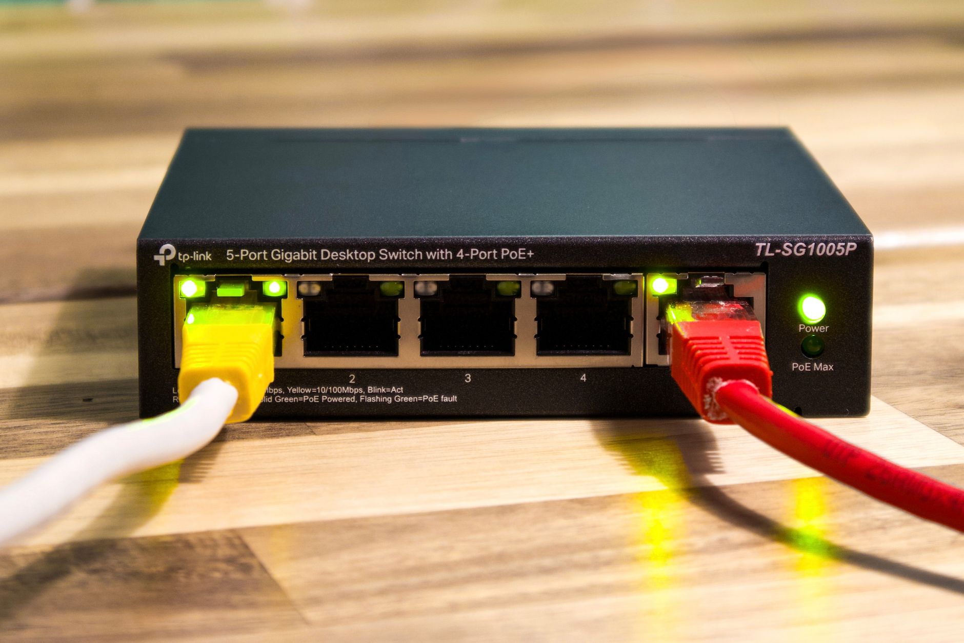 A wireless access point mounted to the ceiling infrastructure of a large warehouse, ensuring network connectivity for integrated systems.