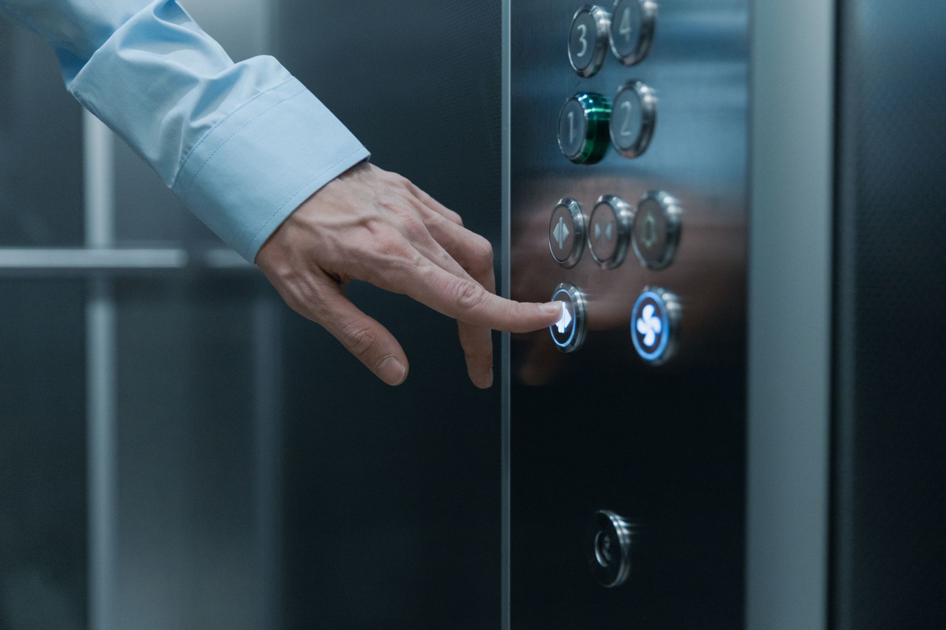 Close-up of modern elevator call buttons, which a BMS can control to enable multi-floor delivery for service robots.