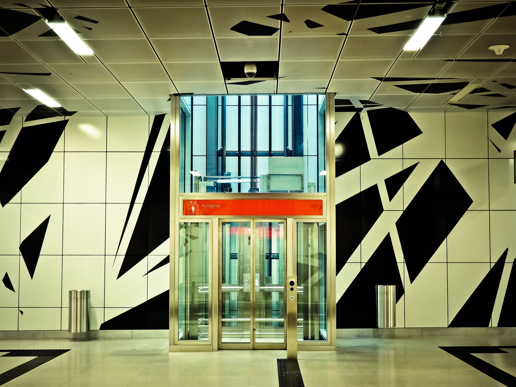 A sleek, modern elevator bank in a well-lit corporate building, representing the intersection of architecture and automated systems.