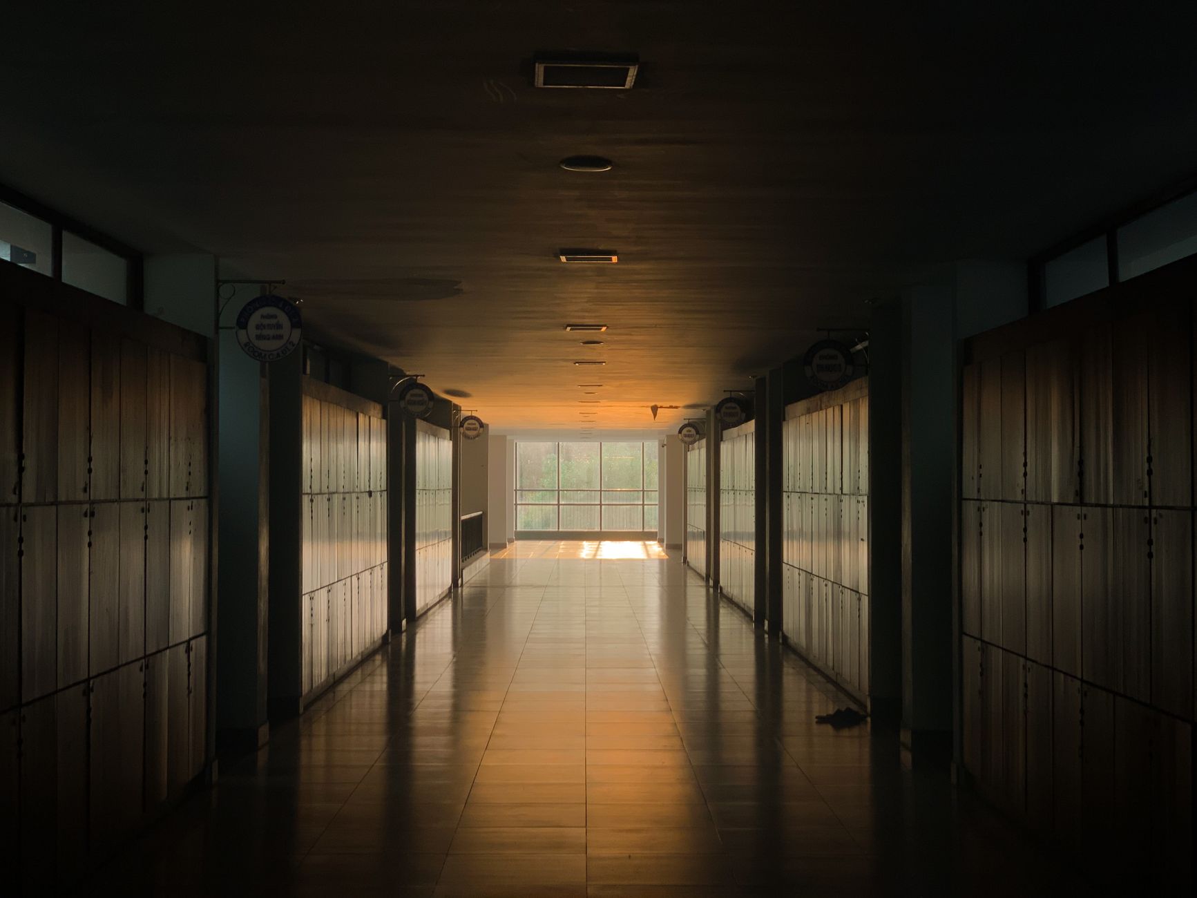 A quiet school hallway after hours, showing the kind of large routine floor area that must be reset before the next day starts.