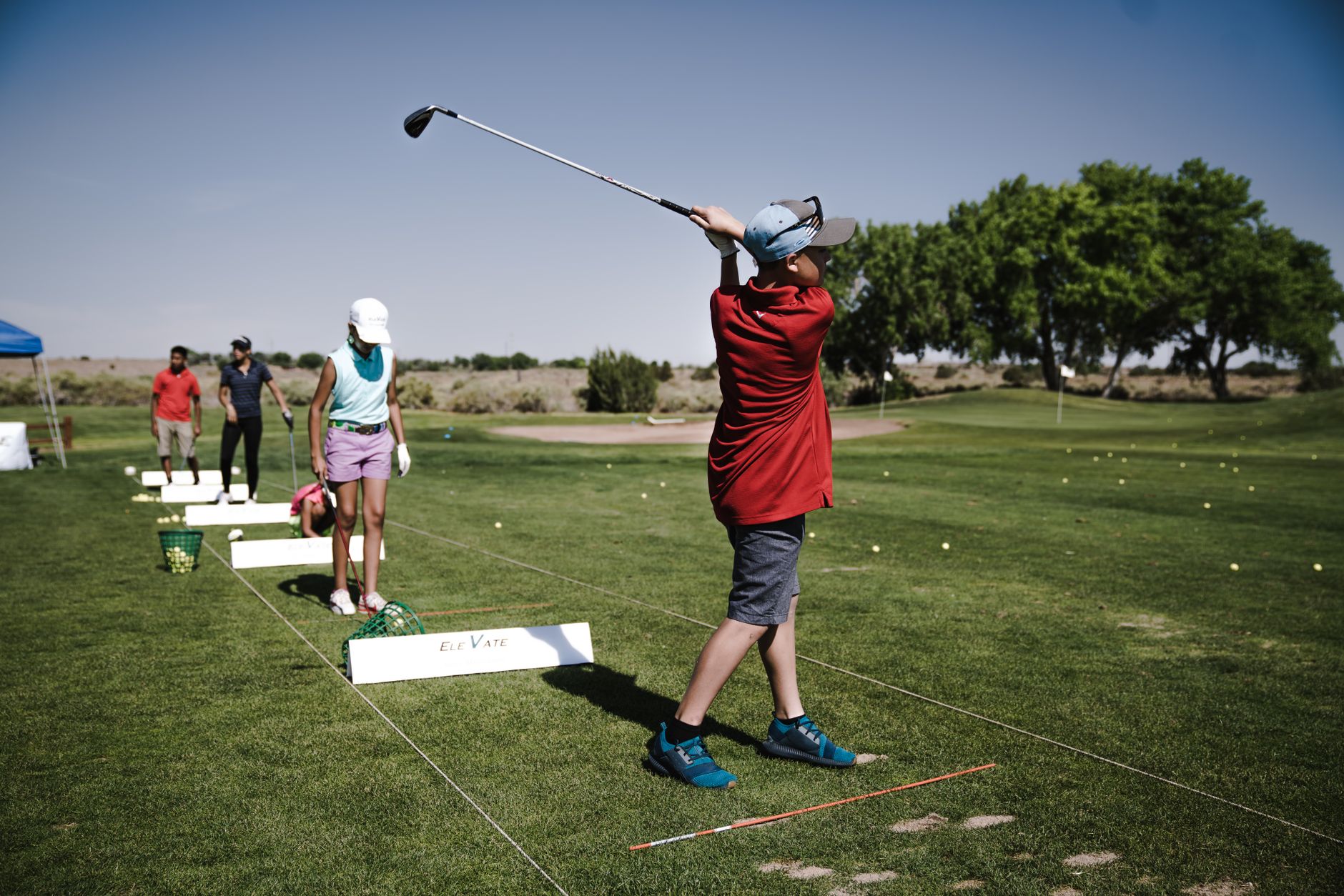 Morning range activity beside fairways used for junior clinic rotations.