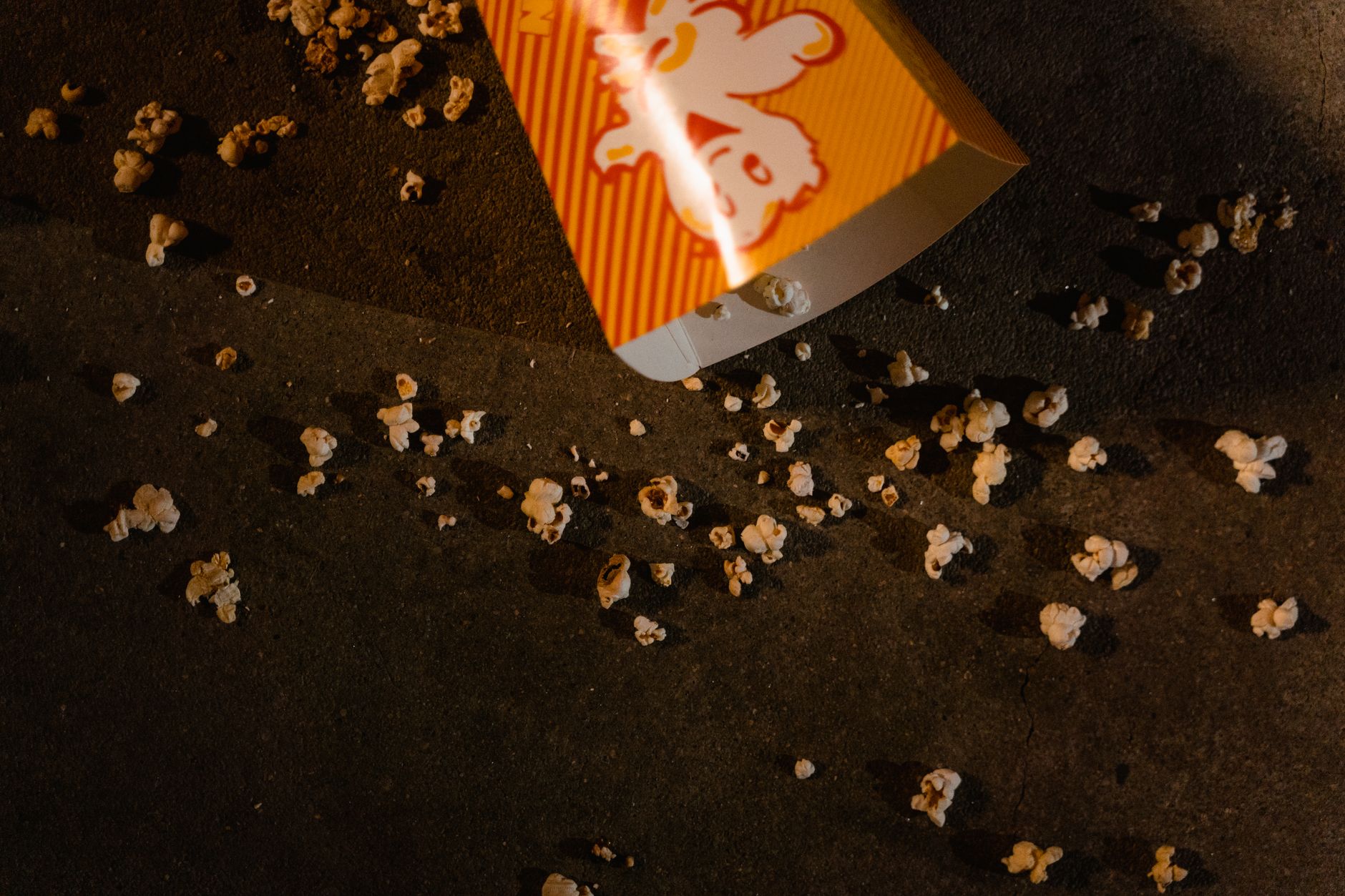 A spilled cocktail creates a sticky, colorful mess on the intricate pattern of a casino carpet, illustrating a common cleaning challenge.