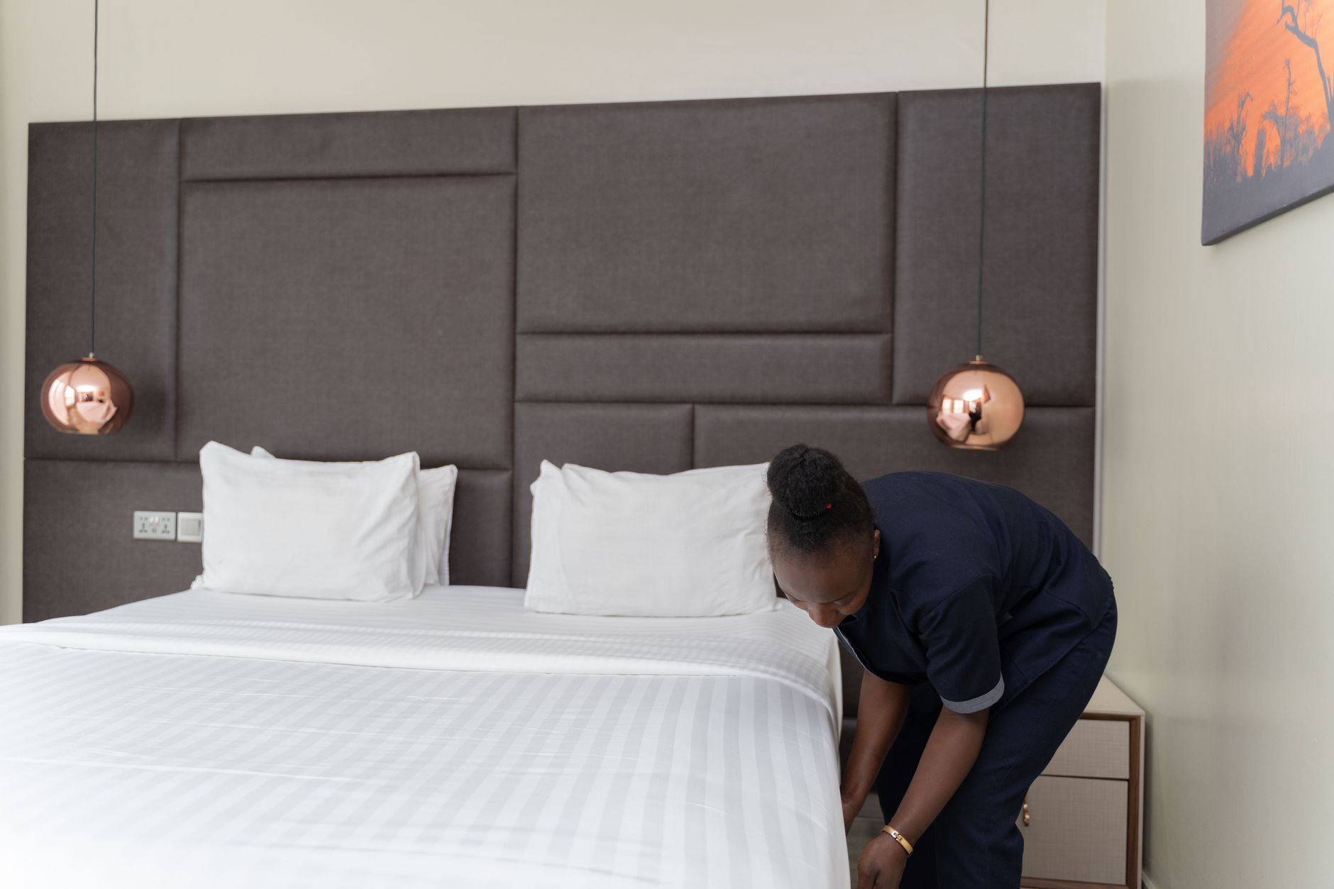 A member of the hotel cleaning staff focuses on a detailed task like spot-treating a stain on a carpet, work that is enabled by automating broad-area vacuuming.