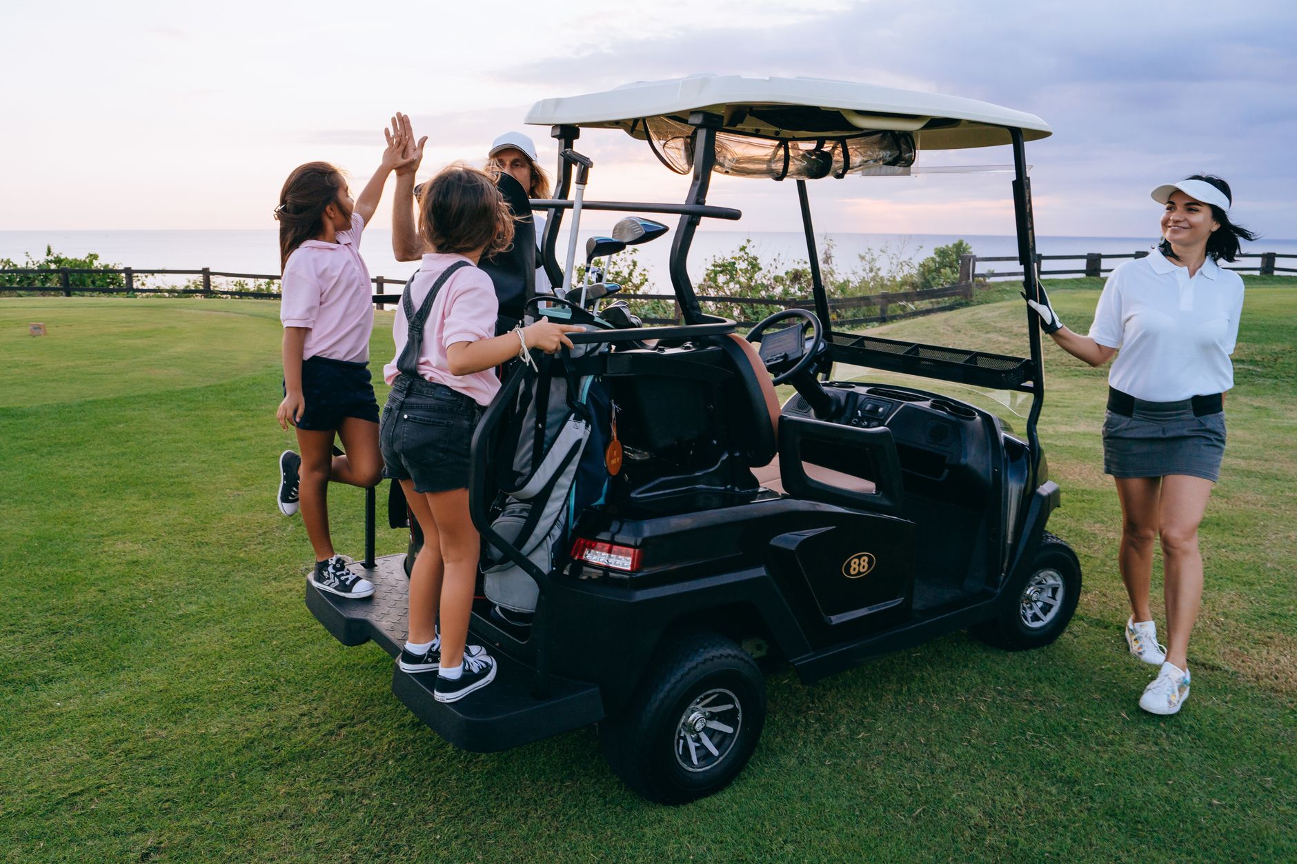League golfers socializing on a fairway where cart spread widens during ladies day play.