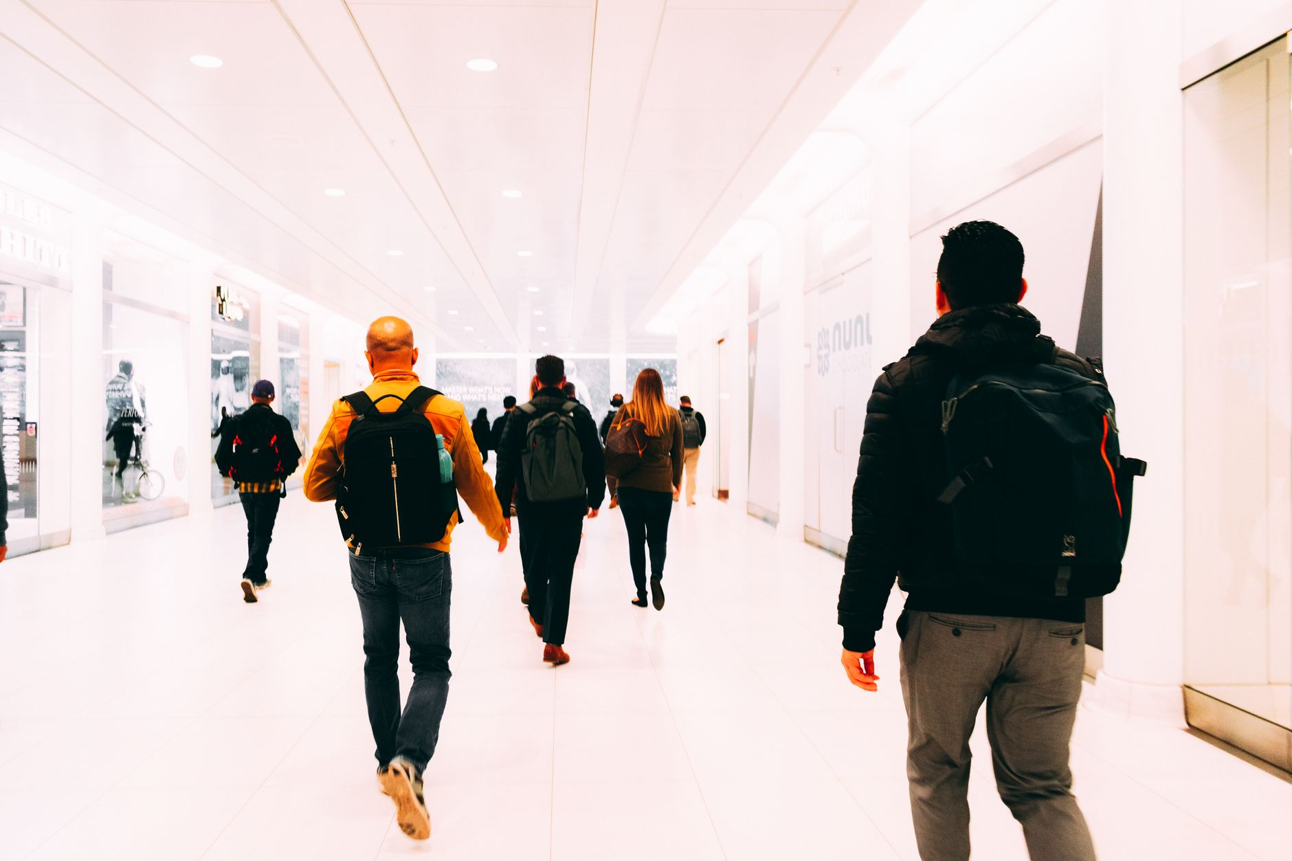 Travelers moving through a busy terminal corridor, showing the pedestrian density and circulation constraints that make airport operations difficult.
