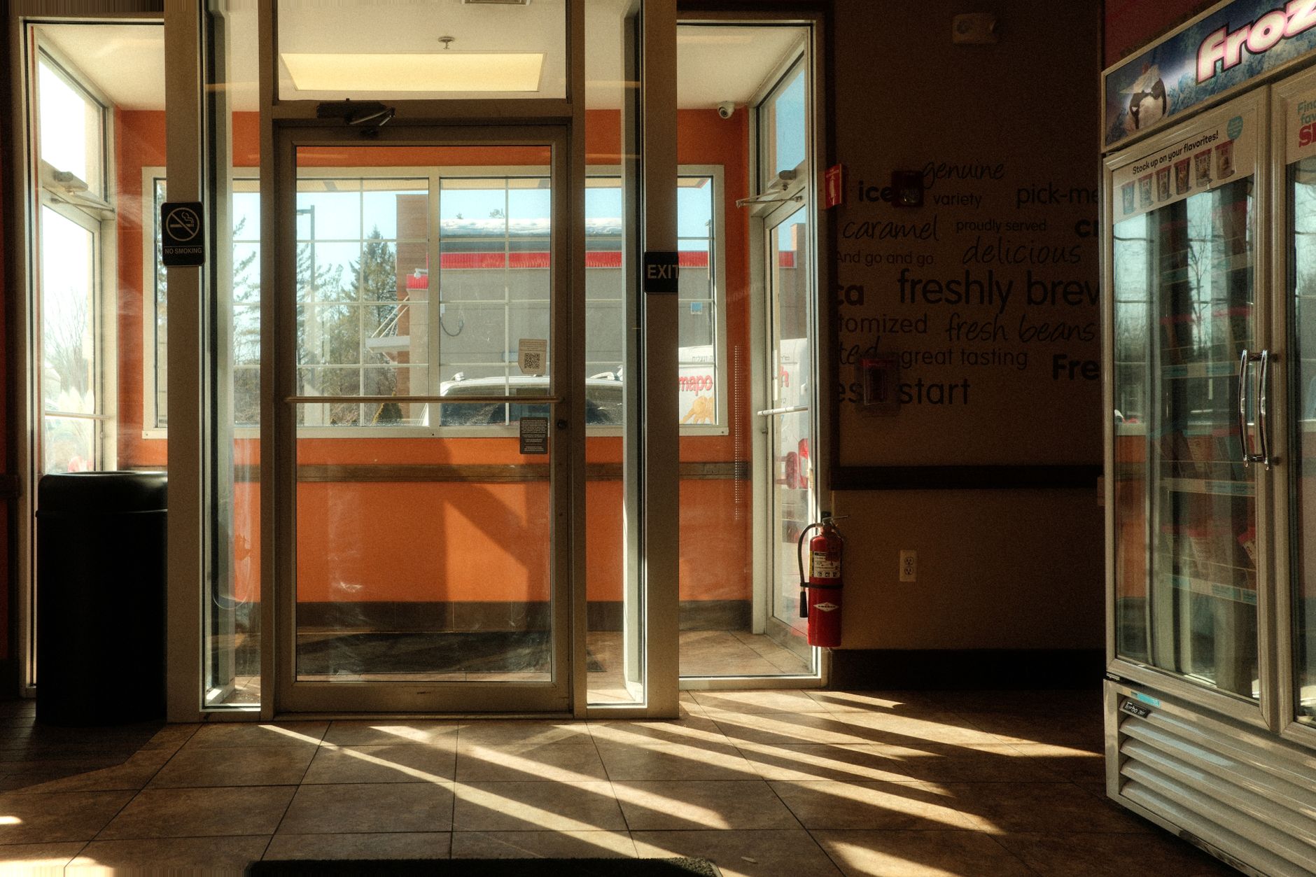 Retail store entrance with hard flooring near a busy commercial corridor