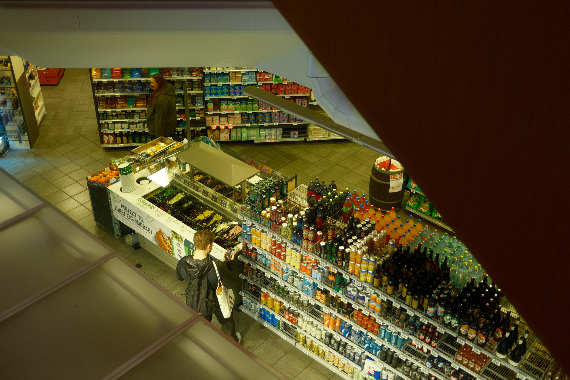 Wide view of a convenience store aisle with tile flooring