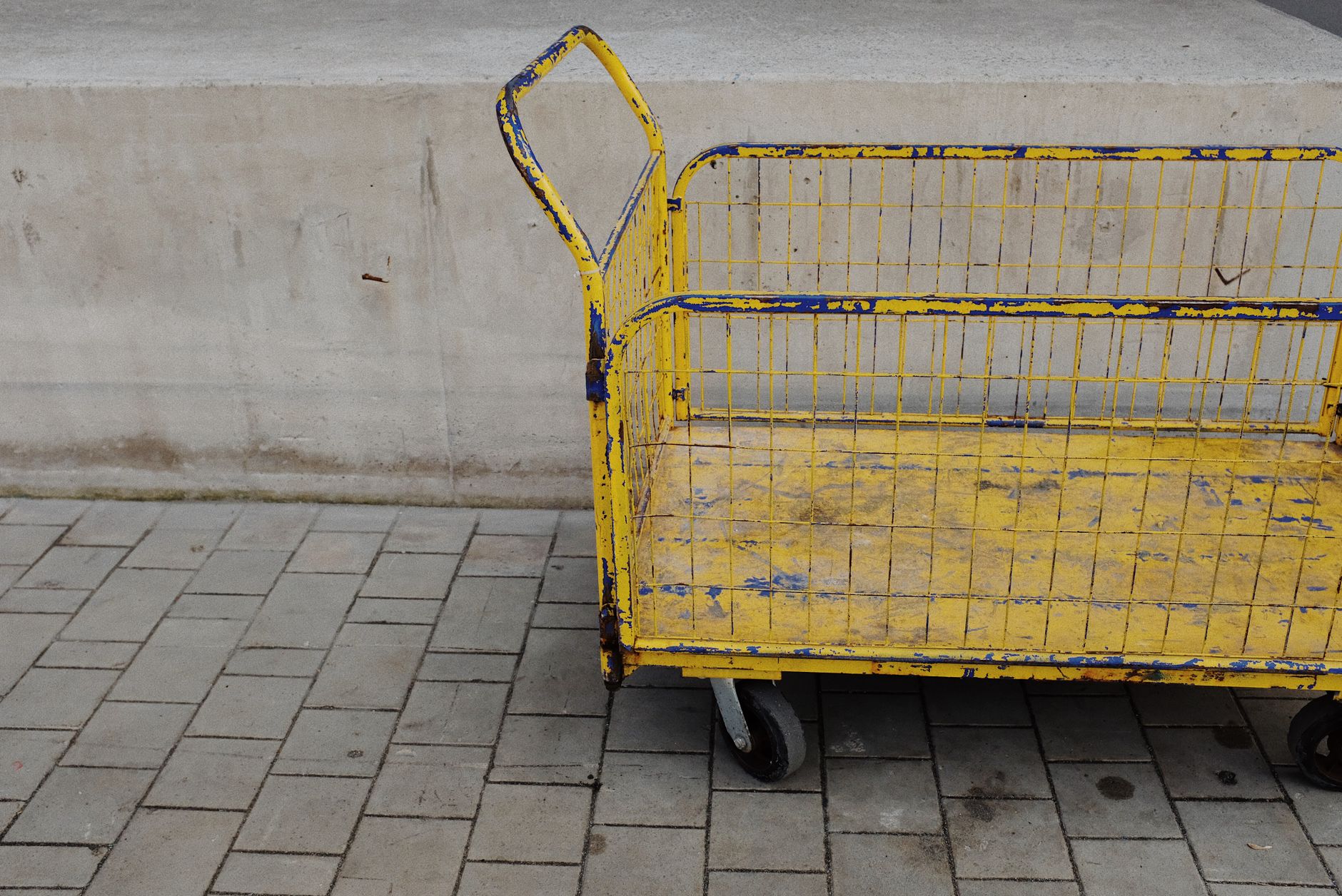 Utility carts staged along a warehouse aisle reflect the batch replenishment loops where moving the whole carrier matters more than single-tote presentation.