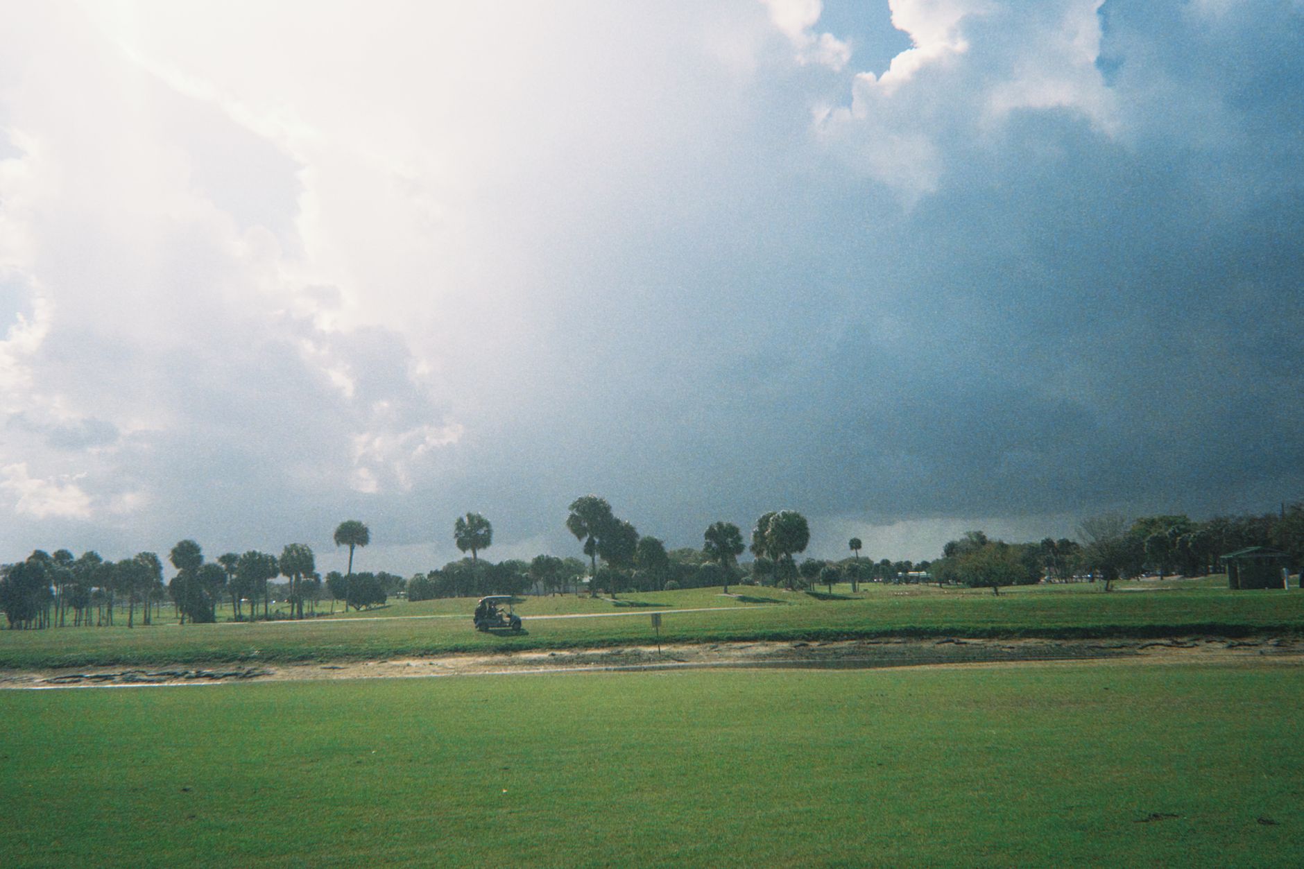 Storm clouds building over a golf course fairway
