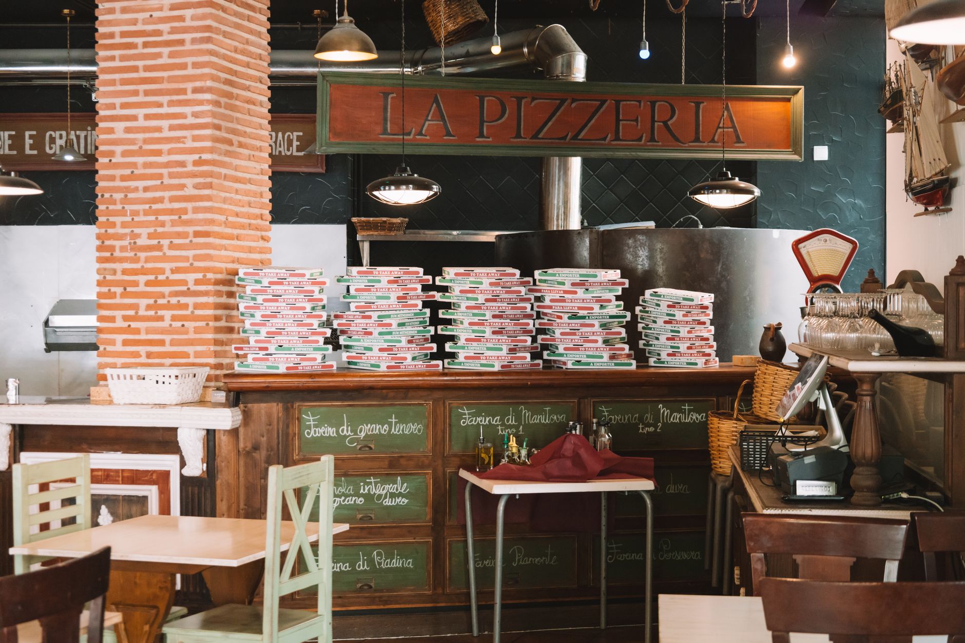 Stacked pizza boxes at a restaurant counter, showing the simple packaged orders that best fit short urban delivery runs.