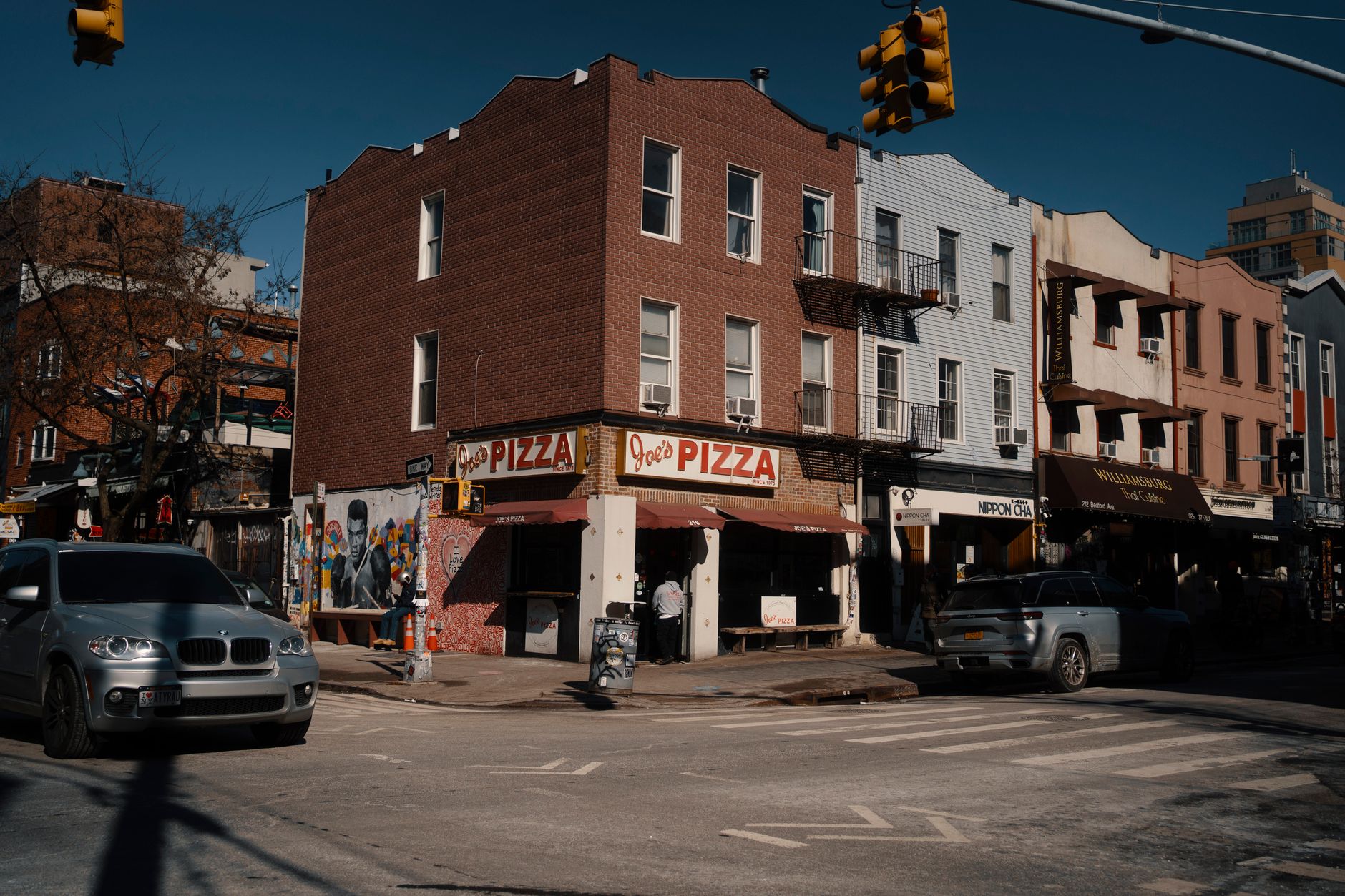 Street-level view of a busy pizza storefront in a dense city neighborhood, illustrating the kind of short-radius delivery environment Little Caesars is testing.