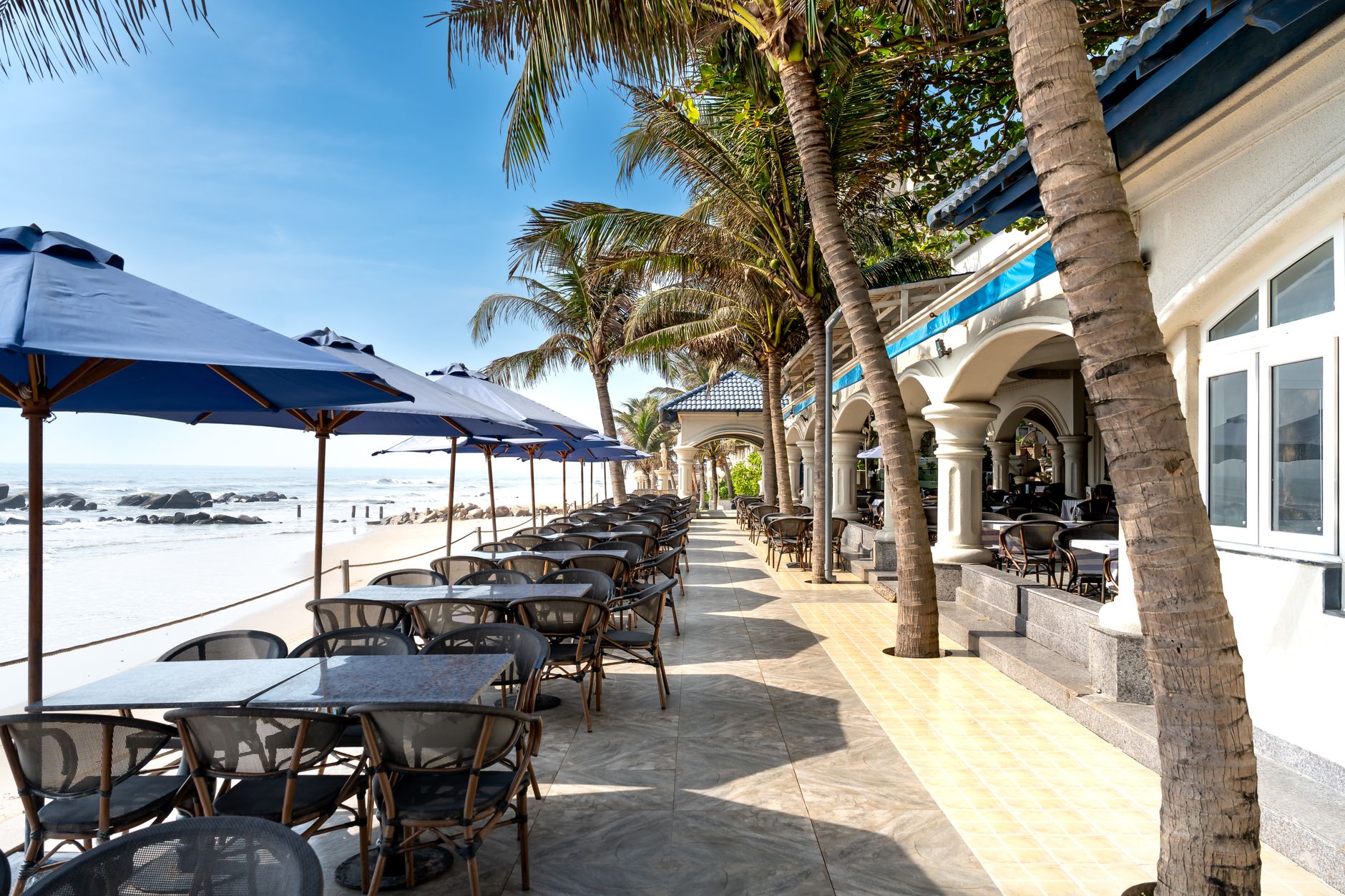Outdoor resort dining tables that see heavy tray traffic during family vacation peaks.