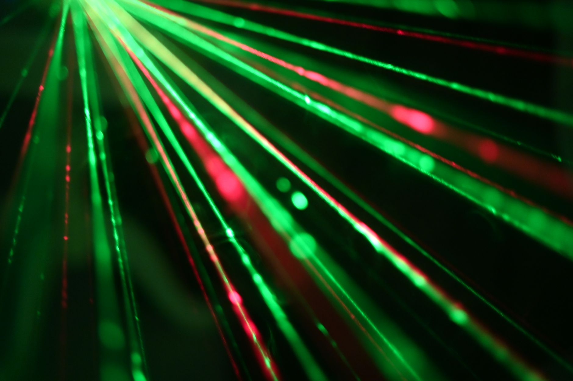 Abstract blue and red laser light beams crisscrossing in a dark space, illustrating the concept of LiDAR sensors collecting data points.