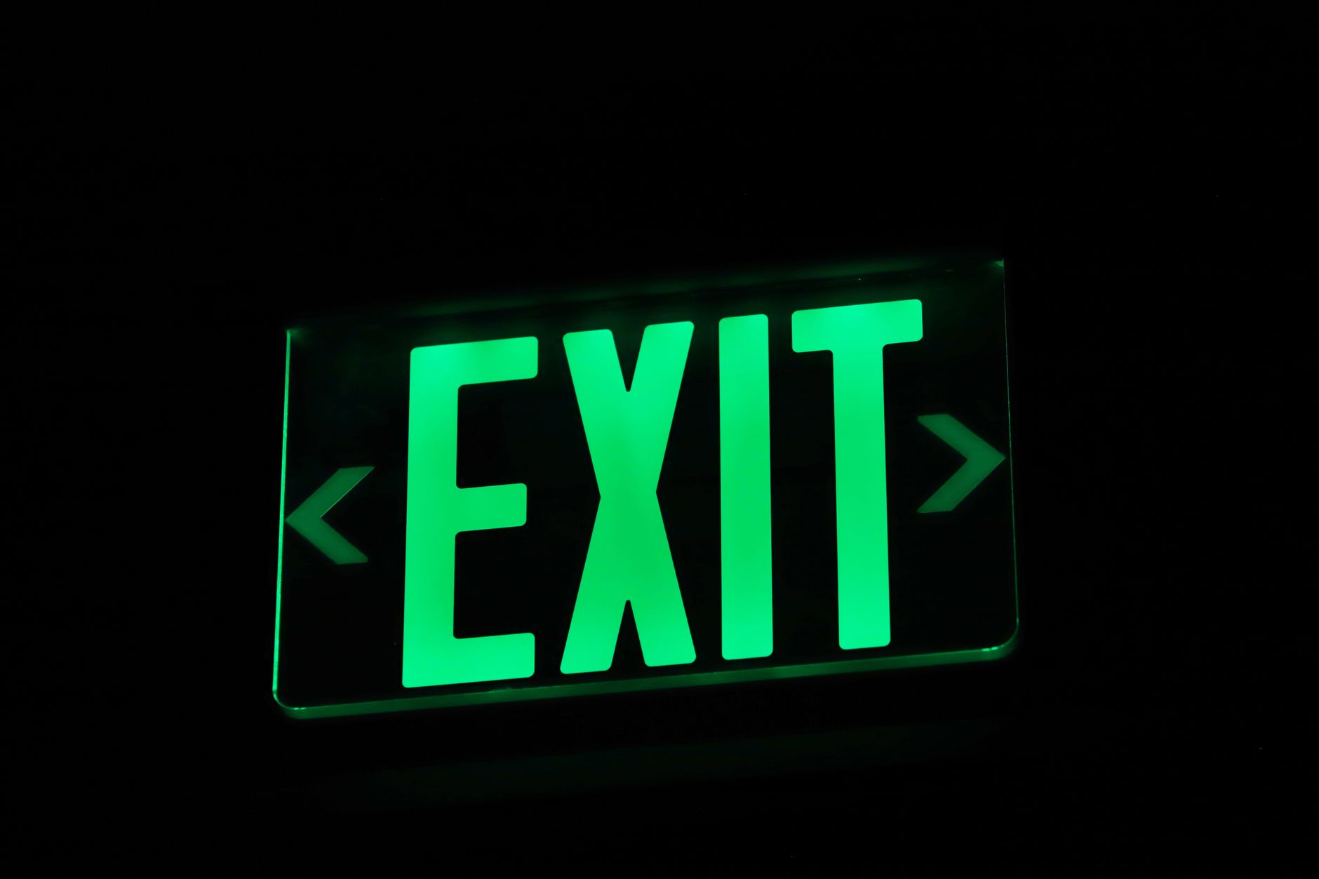 An illuminated exit sign like those inspected during monthly emergency lighting checks.