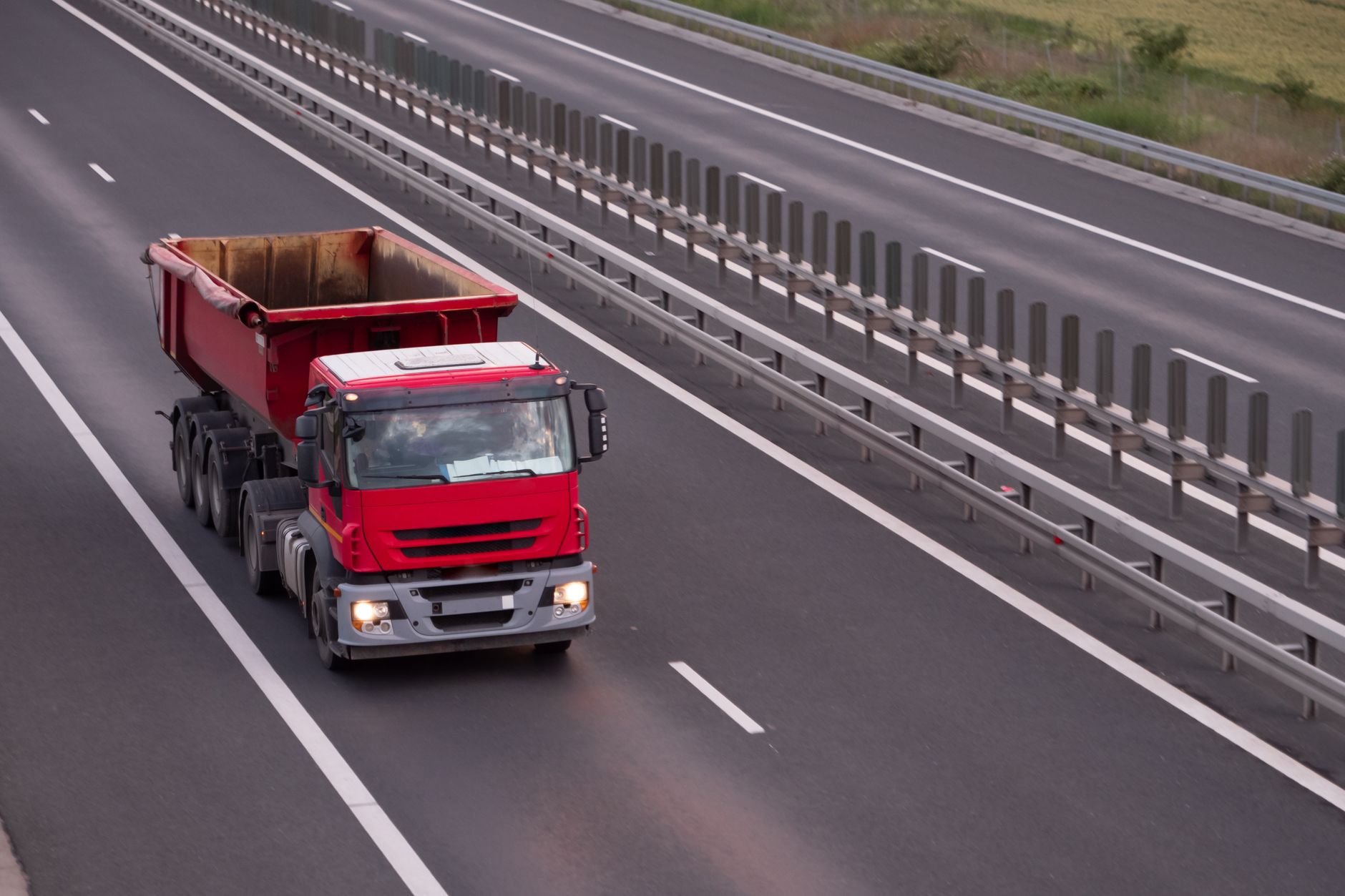 Semi truck on a highway near industrial buildings