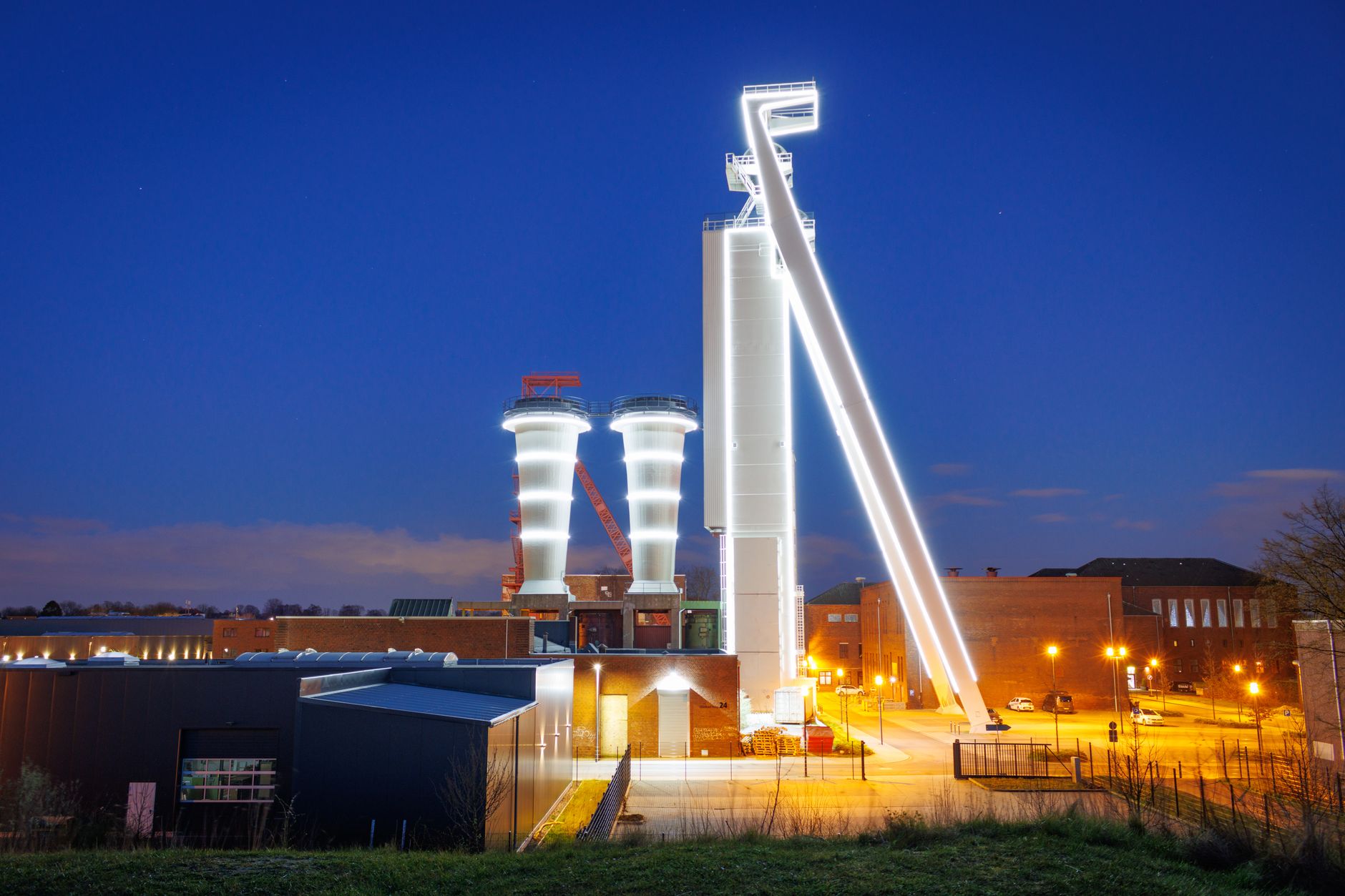 Factory exterior at night with parking lot lights