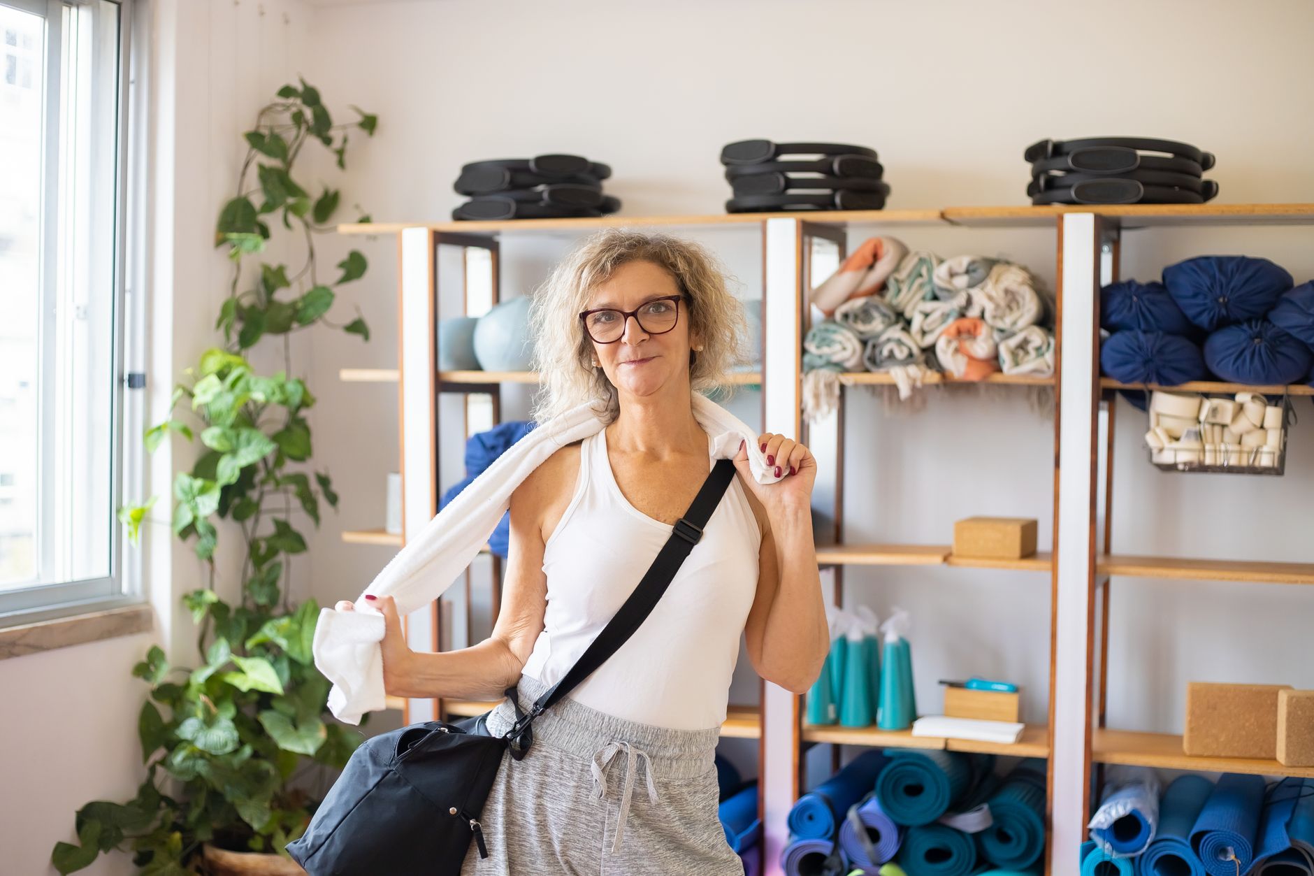 Yoga mats, blocks, and bolsters stored off the floor so an overnight cleaning path stays consistent.