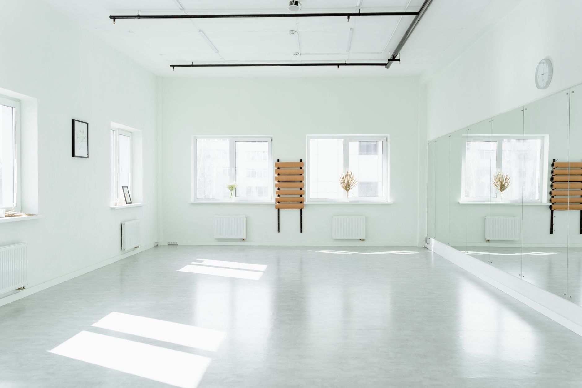 Empty studio with mirrors and a clear sprung floor, the kind of room that benefits from overnight dust and grit removal.