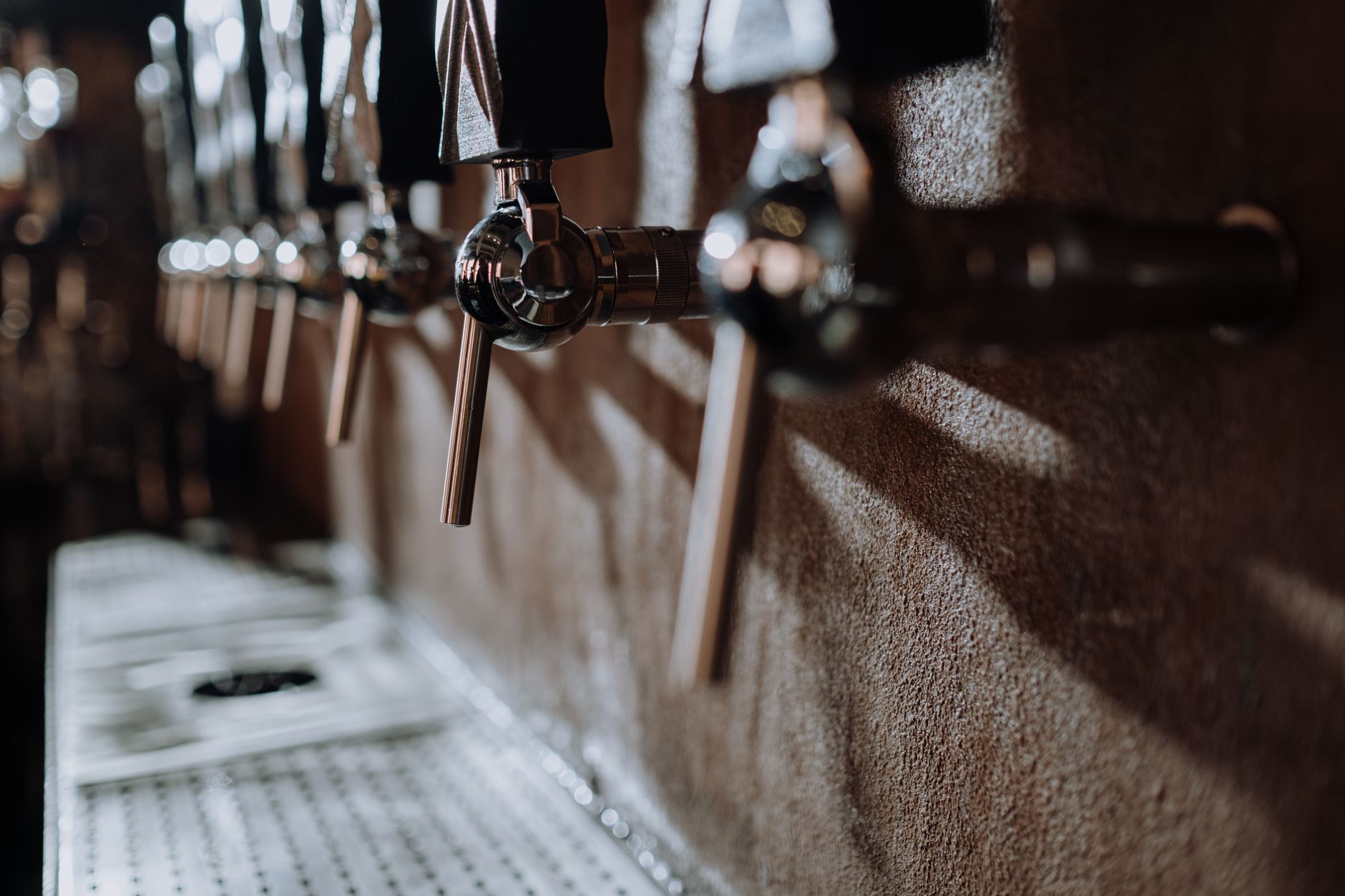 An empty brewery taproom with bar seating and open floor space, the kind of room that needs dependable overnight floor cleaning before morning service.