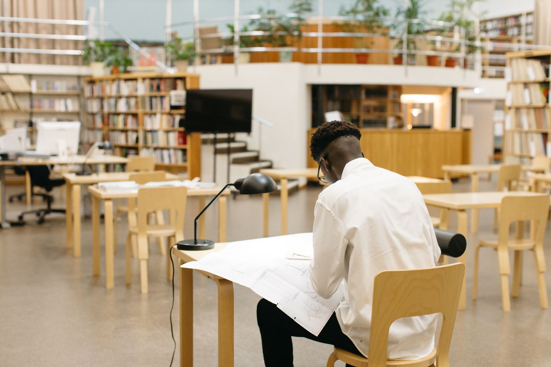 A wide, quiet library with natural light, representing an ideal acoustic environment for daytime robotic cleaning.