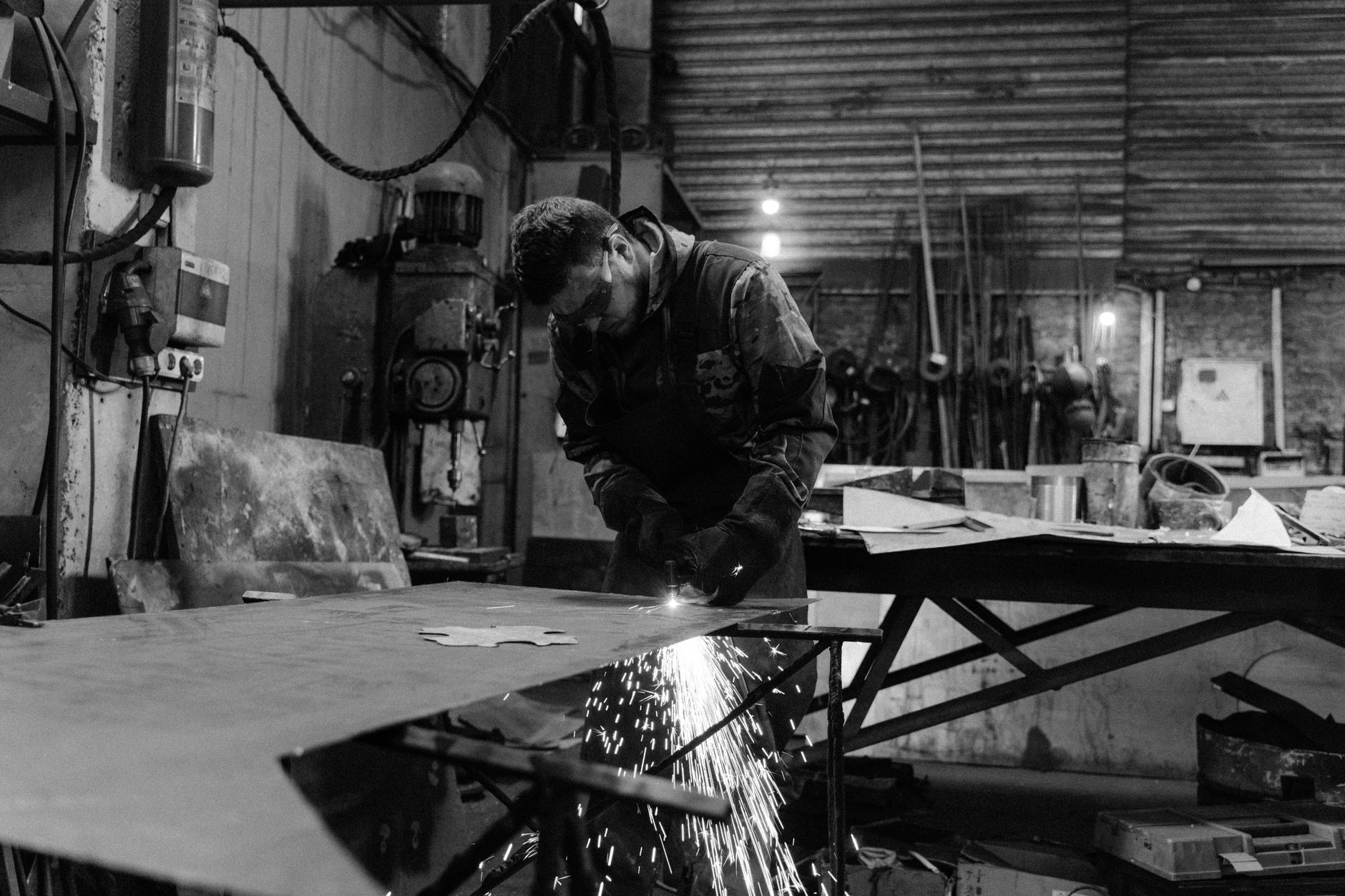 A metalworking employee handles parts on a busy shop floor where throughput, consistency, and ergonomics shape investment decisions.