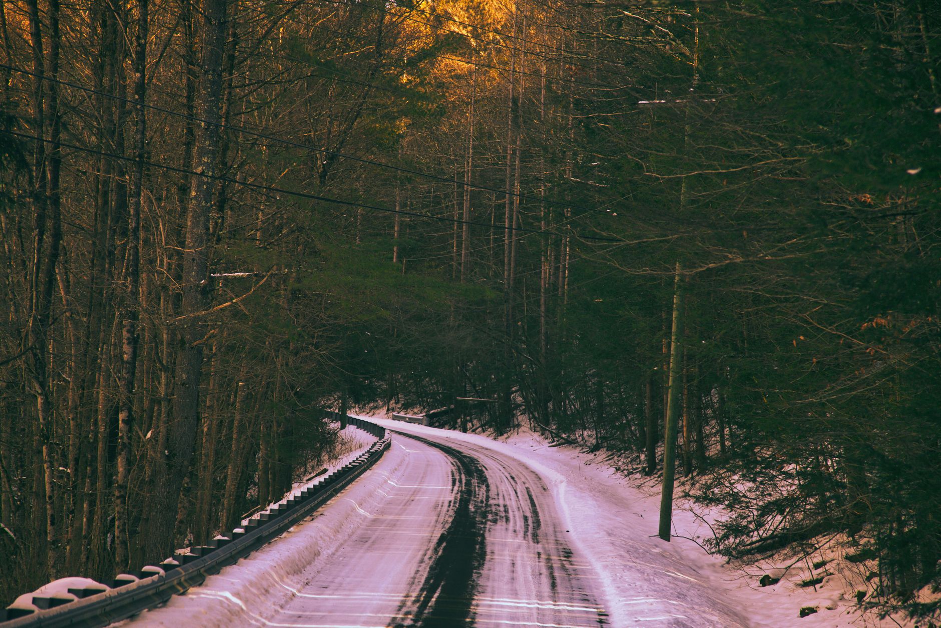 Snowy rural road through hilly countryside