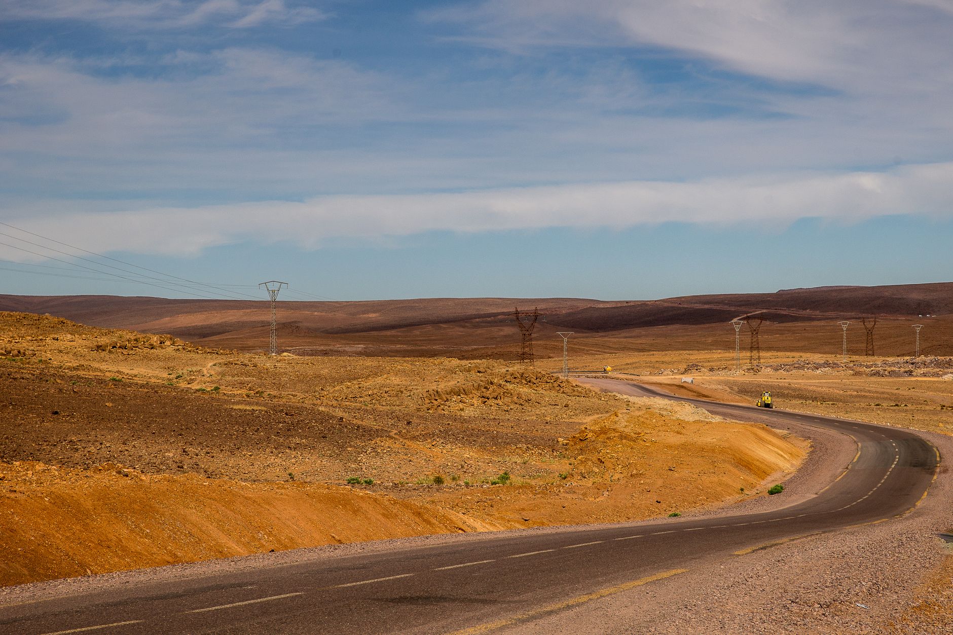 A wide desert highway scene illustrating seasonal travel through a remote western valley.